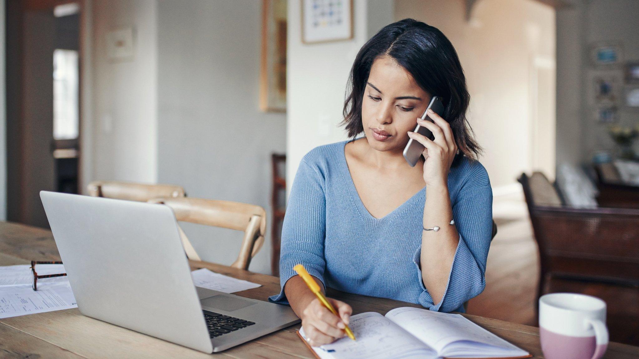 Woman on phone with laptop