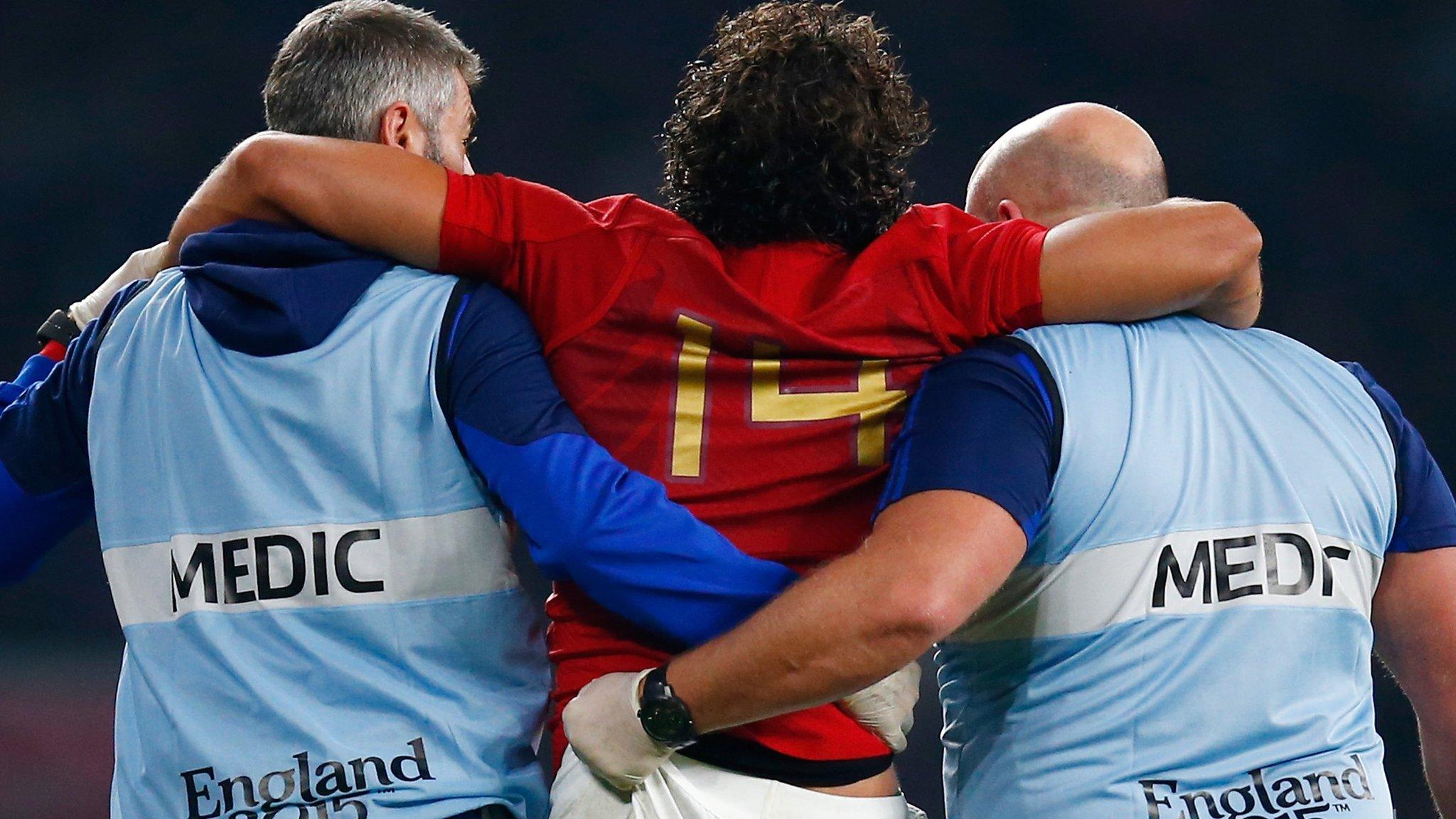 Yoann Huget of France is helped from the field