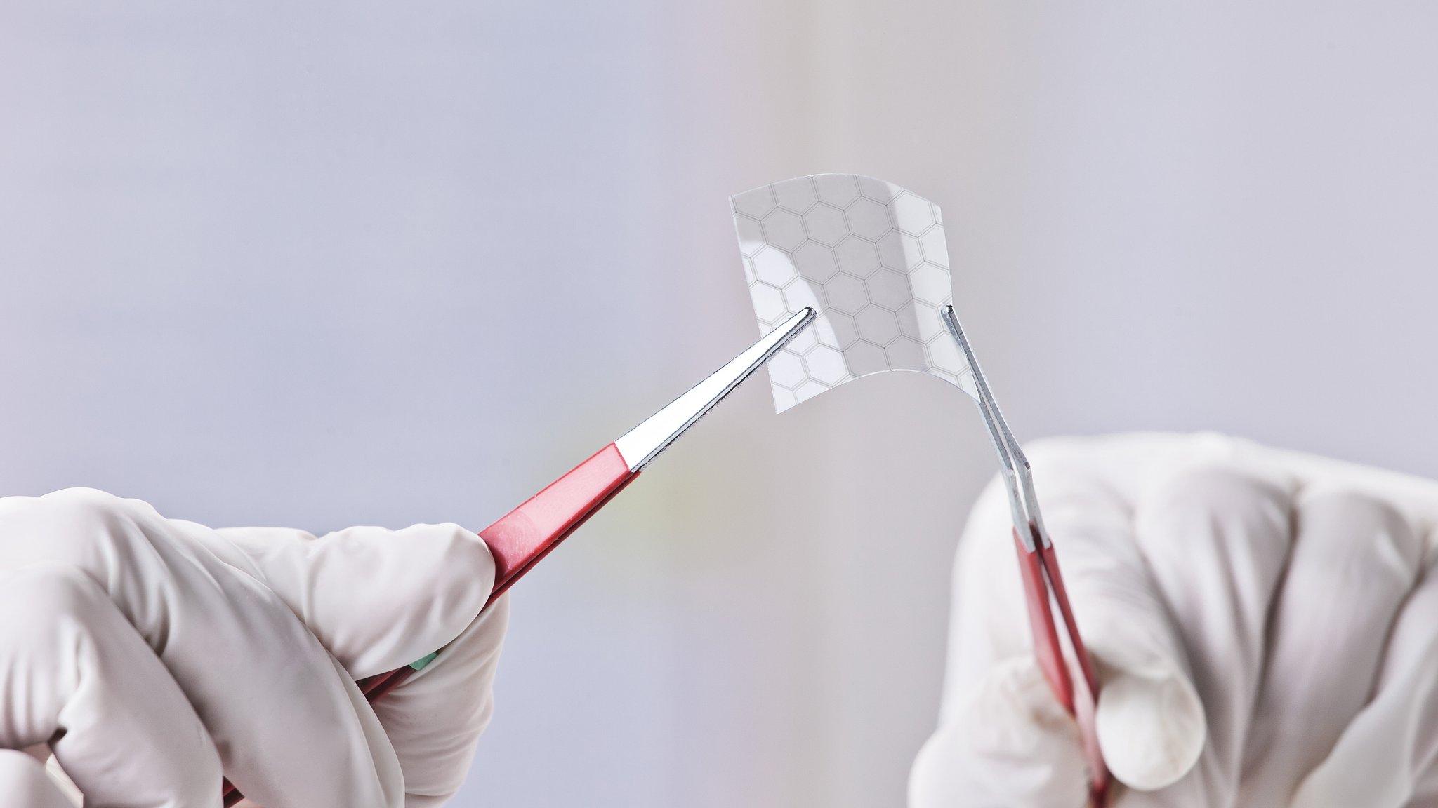 Hands holding a piece of graphene