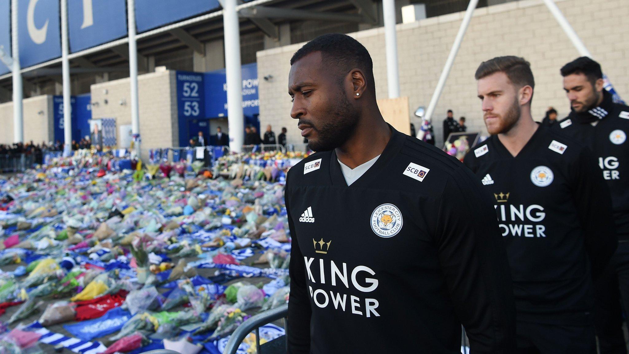 Wes Morgan looks at the floral tributes left to the victims of the helicopter crash which killed Leicester City's Thai chairman Vichai Srivaddhanaprabha, outside the King Power Stadium