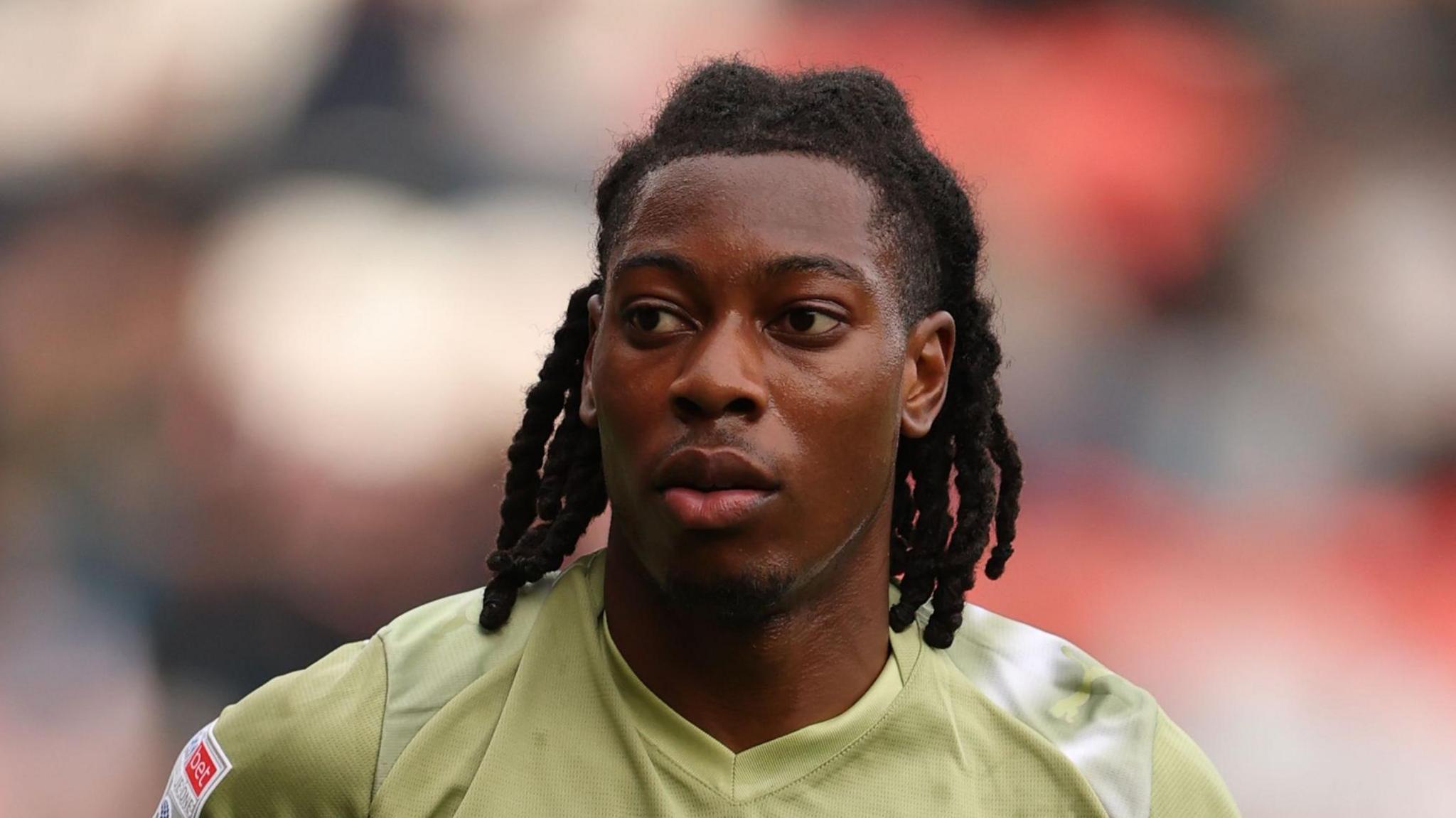 Tayo Adaramola playing for Leyton Orient earlier this season in a lime green away kit