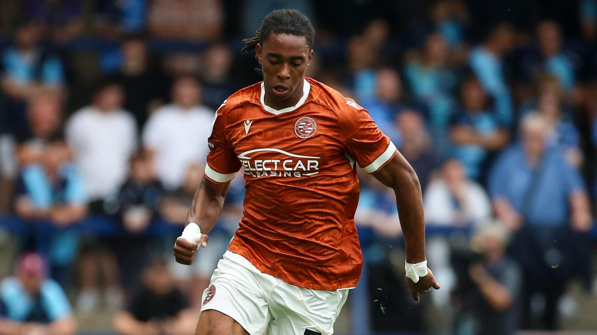 Ashqar Ahmed running with the ball at his feet while looking towards the ground during a game for Reading