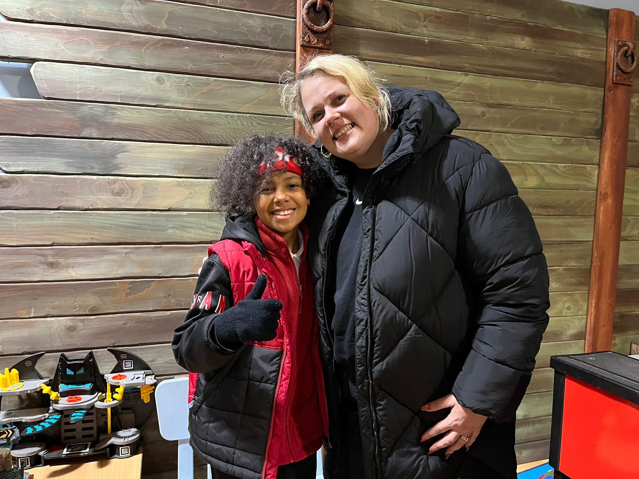 A mum and son smile at the camera inside the sycamore centre