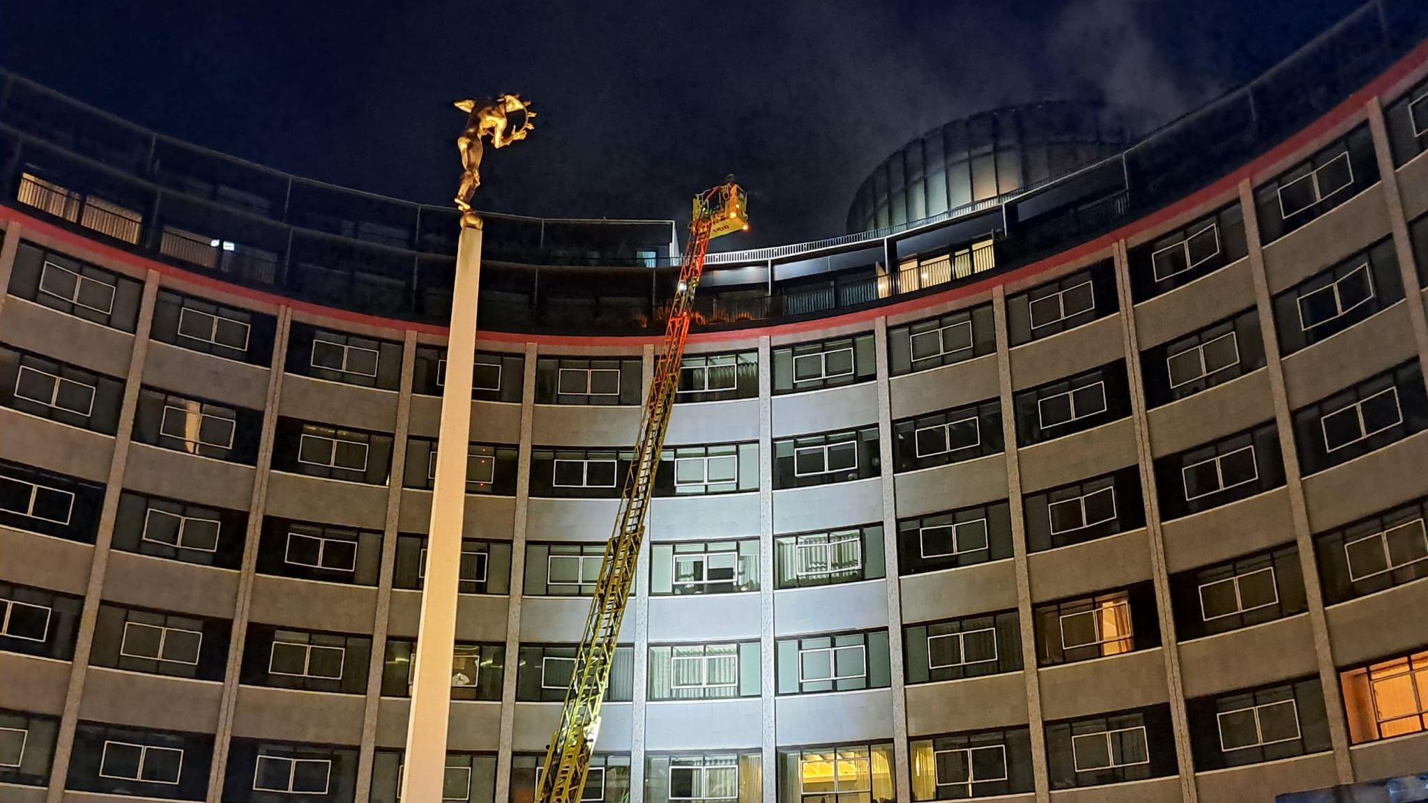 Fire crews tackle fire on top of tall building