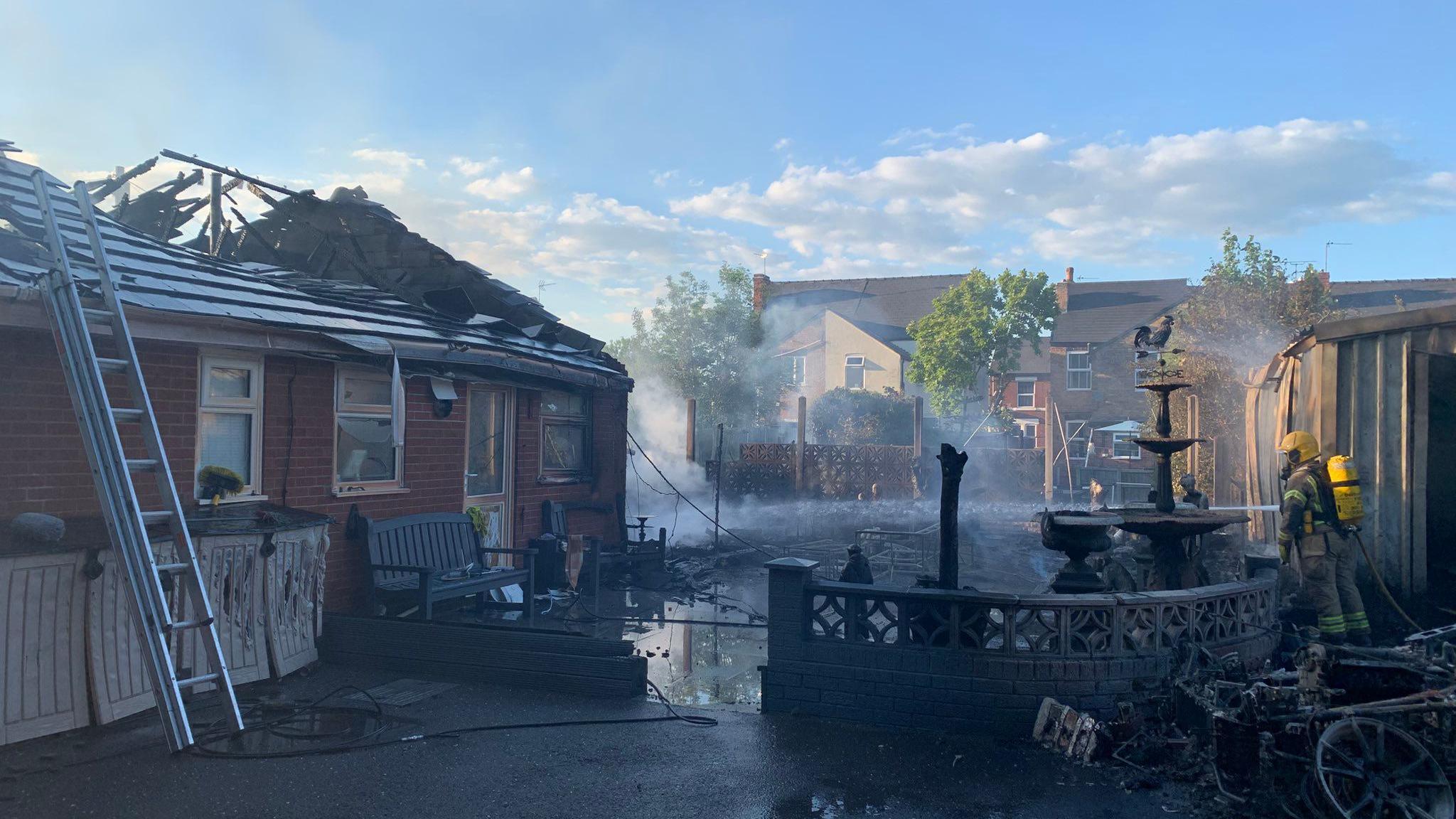 An image showing the damaged caused by a fire which damaged a bungalow and garages including a hole in the bungalow's roof.