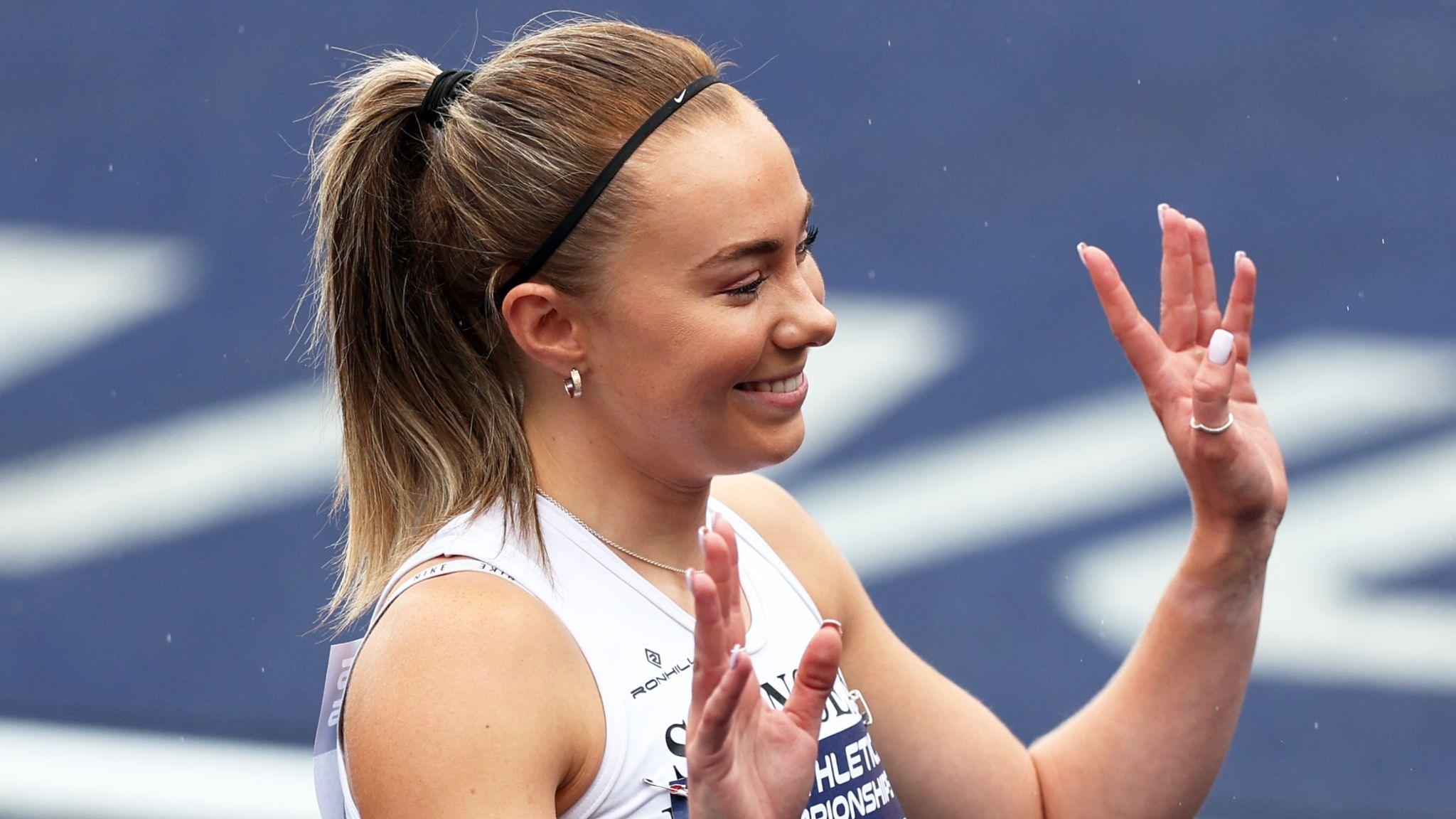 Hannah Brier with hands raised smiling