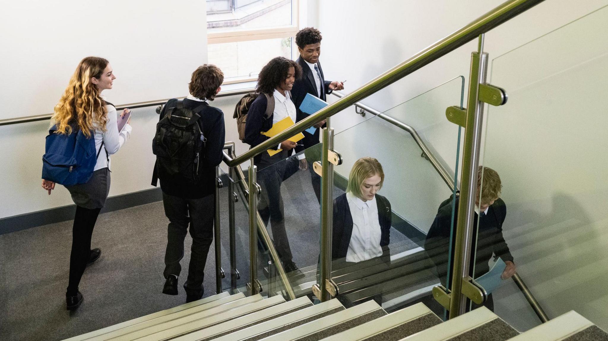 Secondary school children walking down the stairs. 