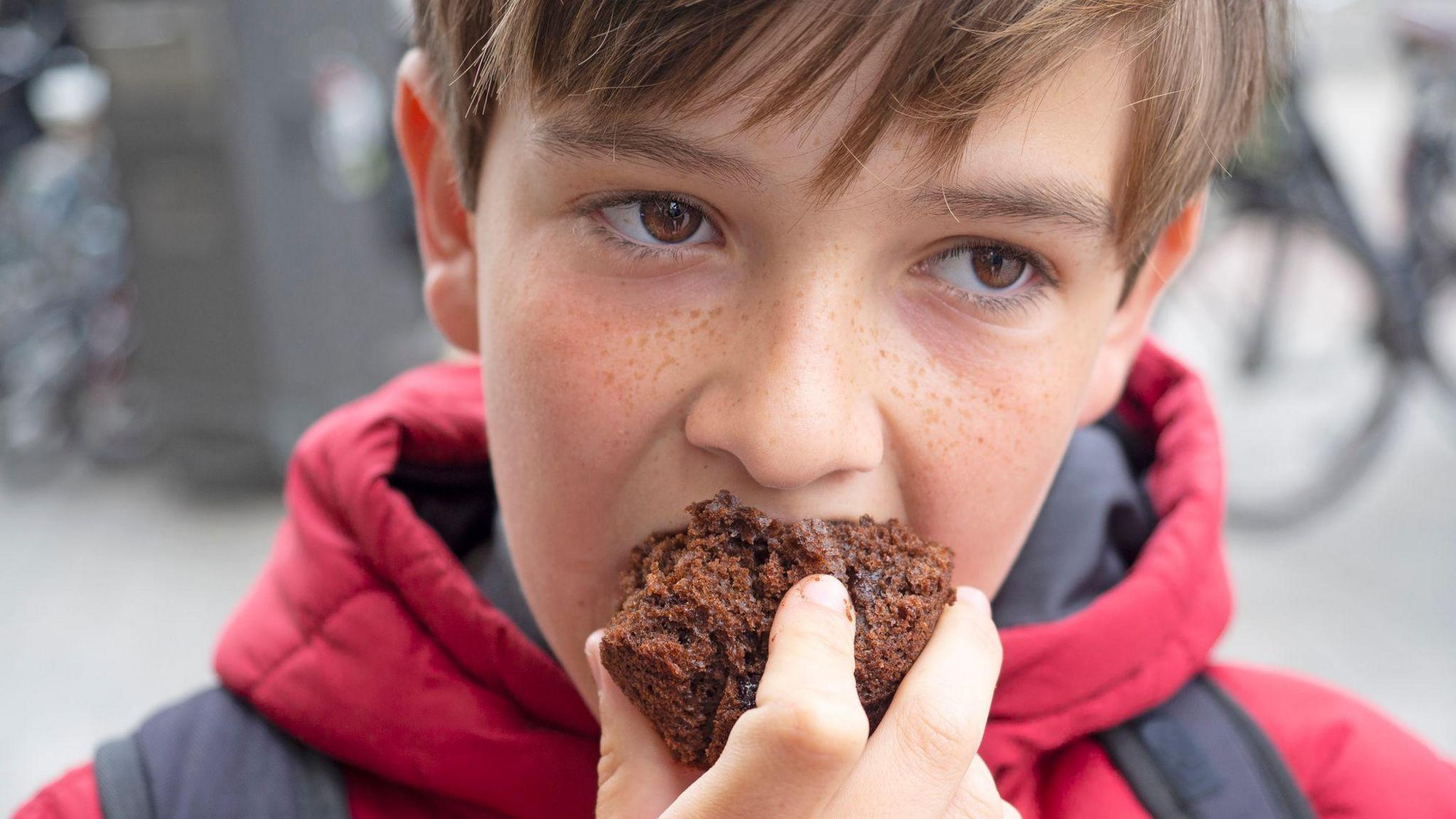 Close-up of boy eating chocolate cake 