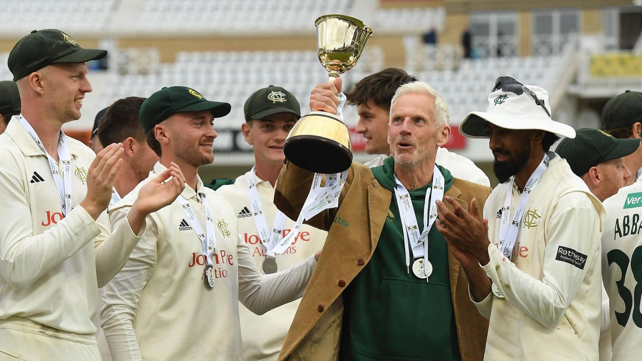 Nottinghamshire head coach Peter Moores holds up the County Championship trophy in 2025
