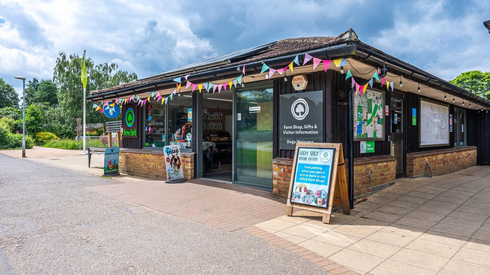 A hut-shaped visitor centre with glass windows and colourful triangular bunting around its roof 