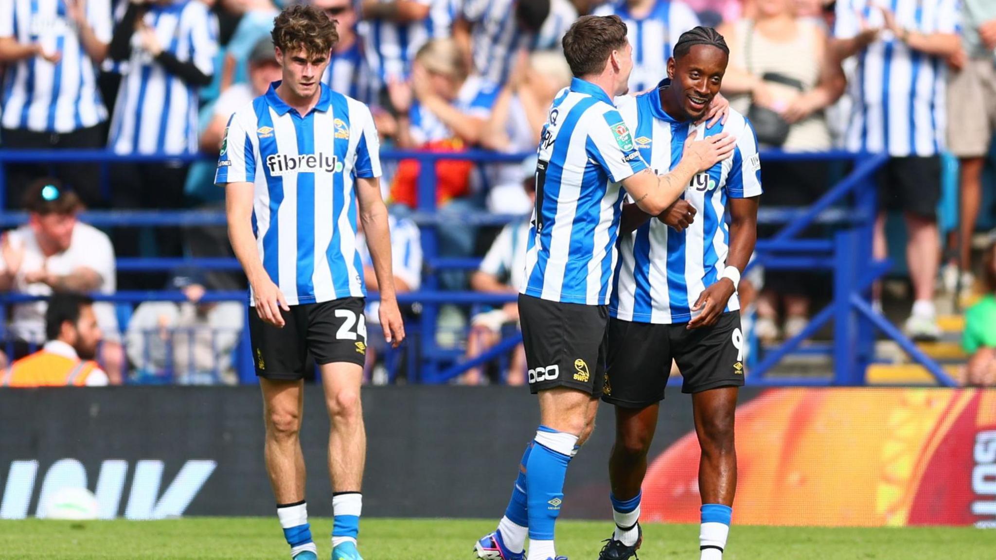 Sheffield Wednesday players, wearing the Owls blue and white striped home shirt, celebrate Jamal Lowe's goal in the EFL Cup against Bolton.