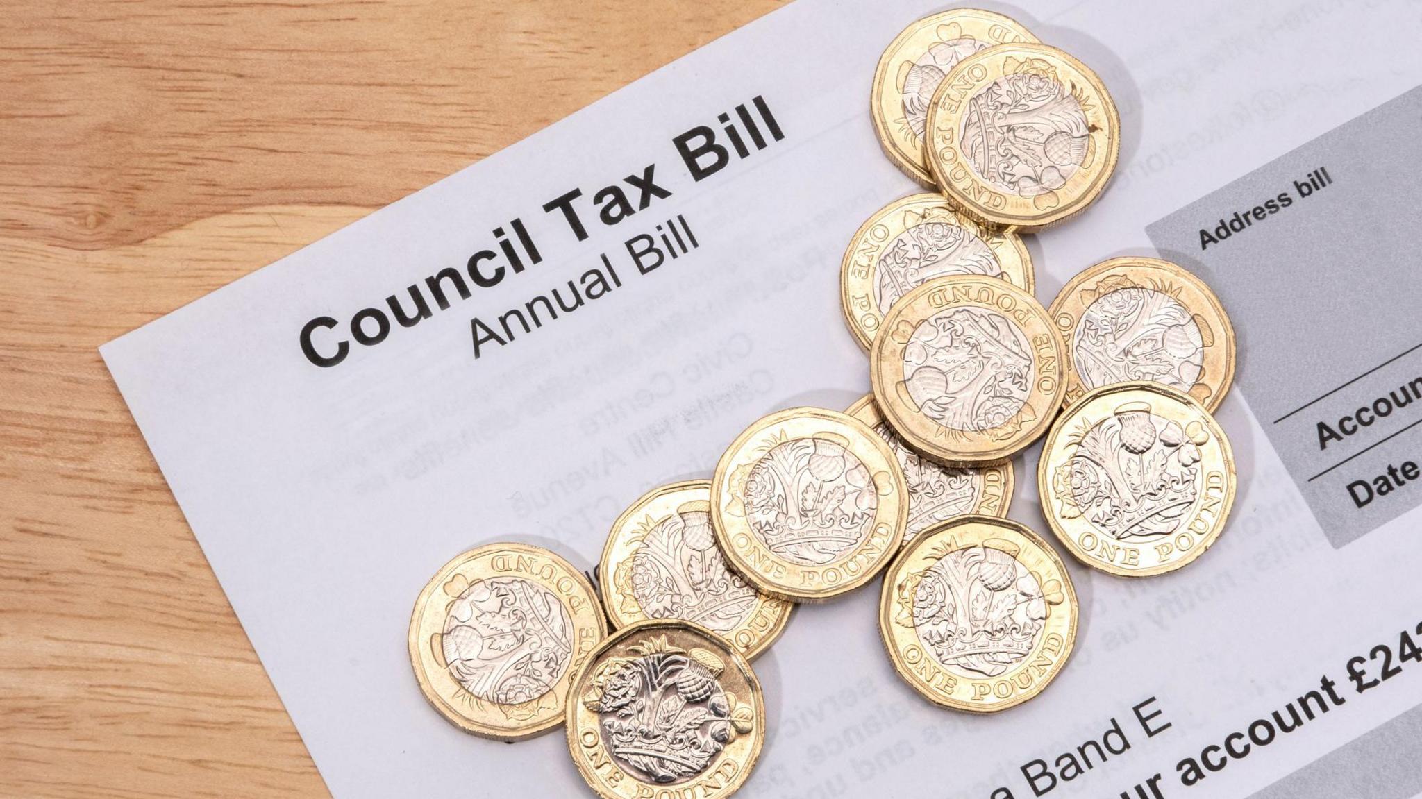 One pound coins placed on a council tax bill.