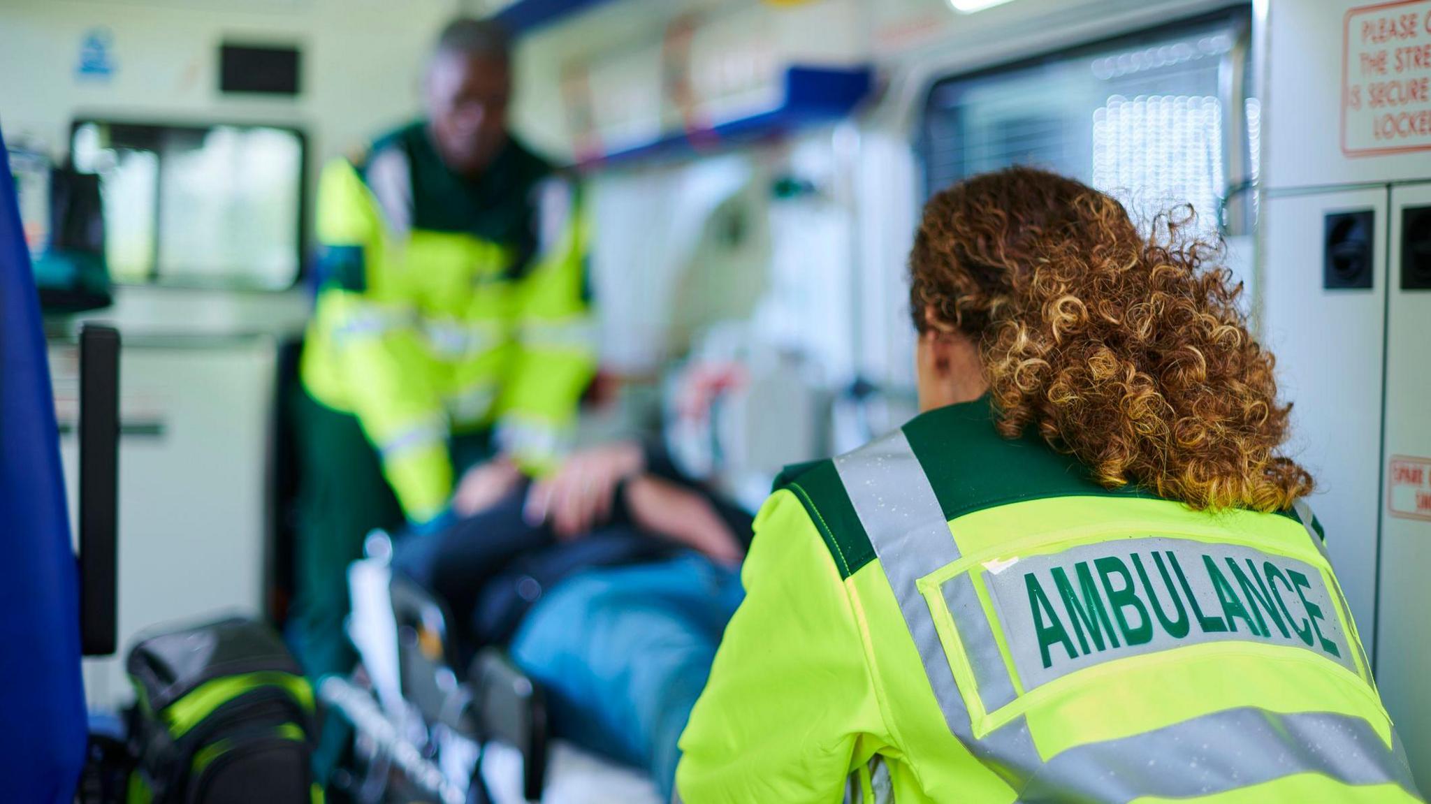 Paramedics carrying stretcher into ambulance