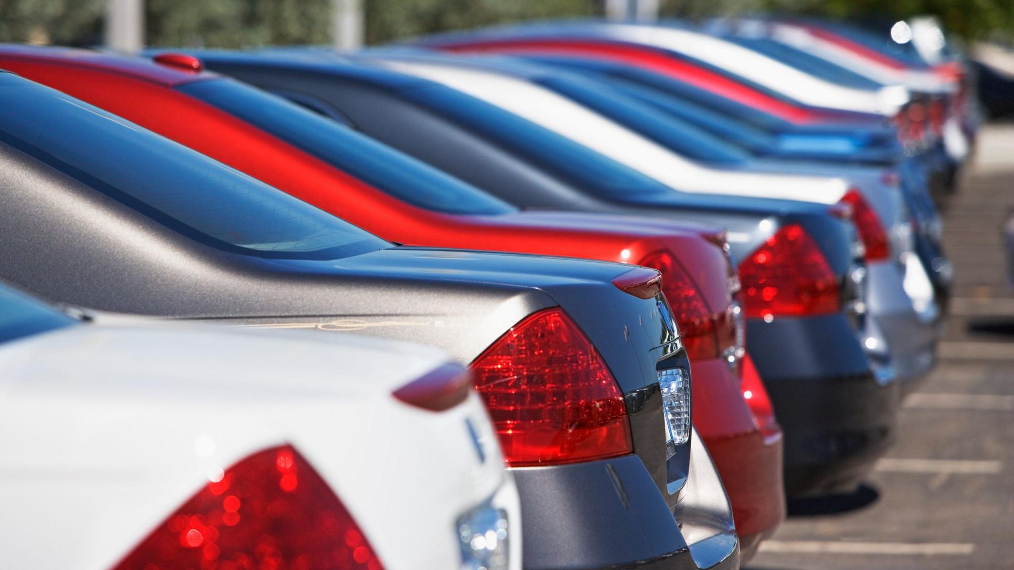 A row of cars sit in a car park in a car park.