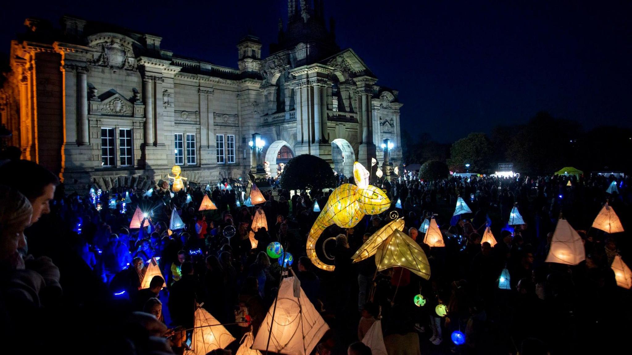 A lantern festival taking lace at night in front of a large official building