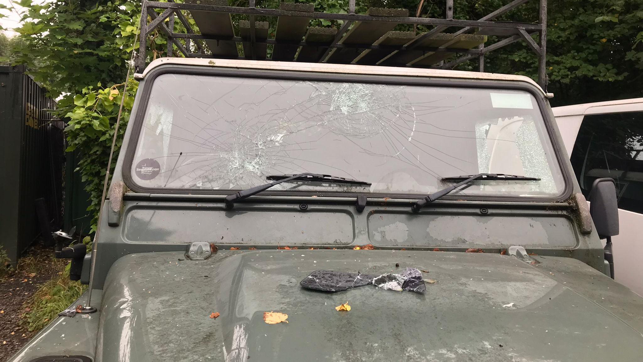 A green Land Rover with a smashed windscreen.