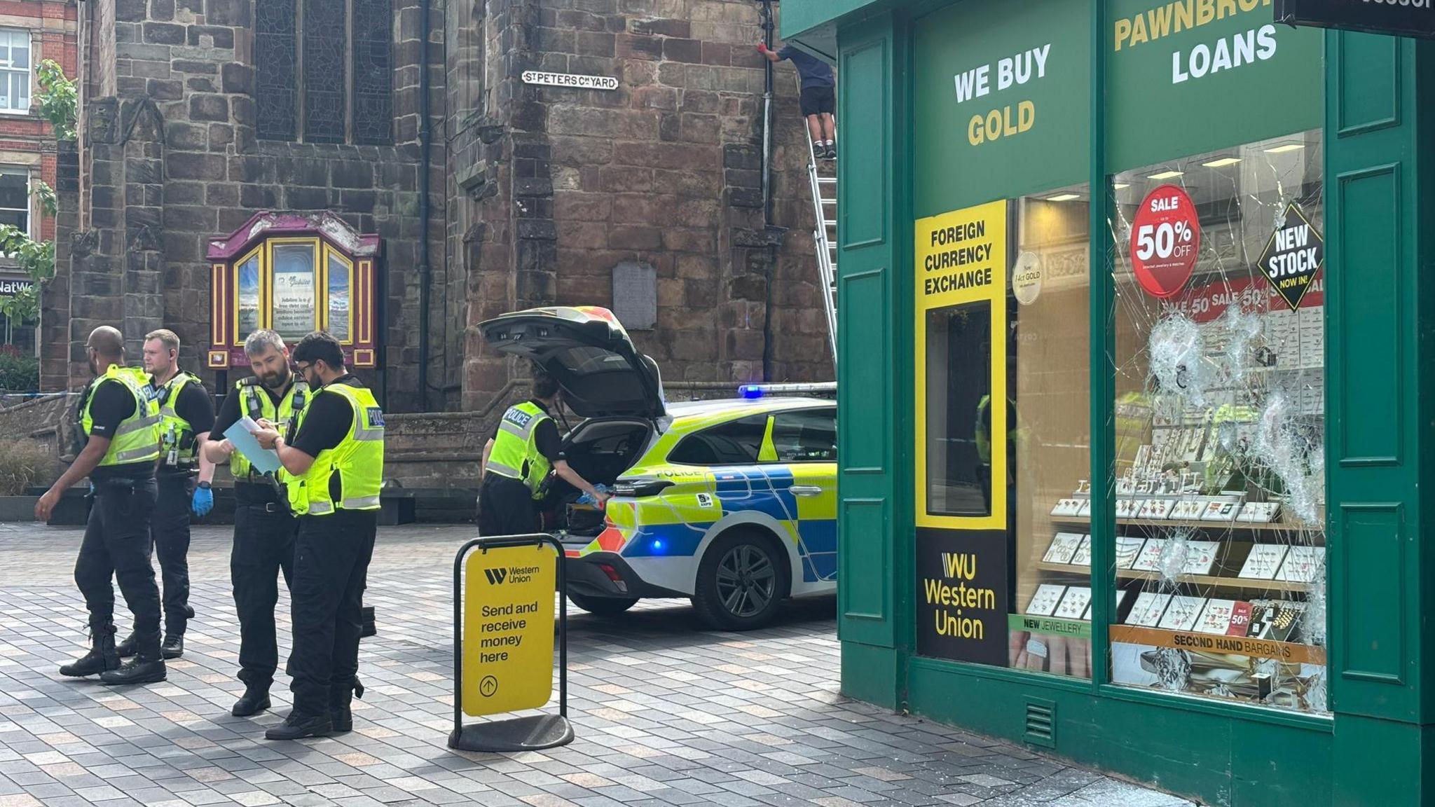 Police near smashed windows of Ramsdens Pawnbrokers