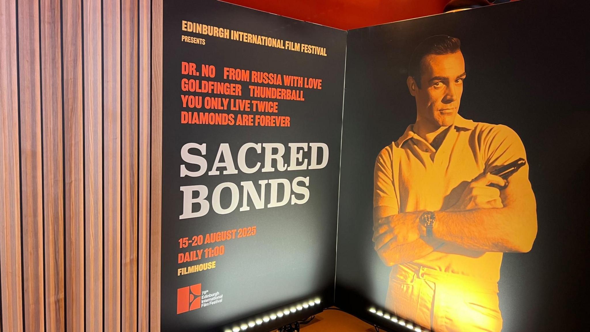 A poster featuring a young Sean Connery with his arms crossed while holding a gun in a classic James Bond pose. The poster also has details of all the Sean Connery Bond films being featured at the film festival under the name Sacred Bonds with the dates they are being shown
