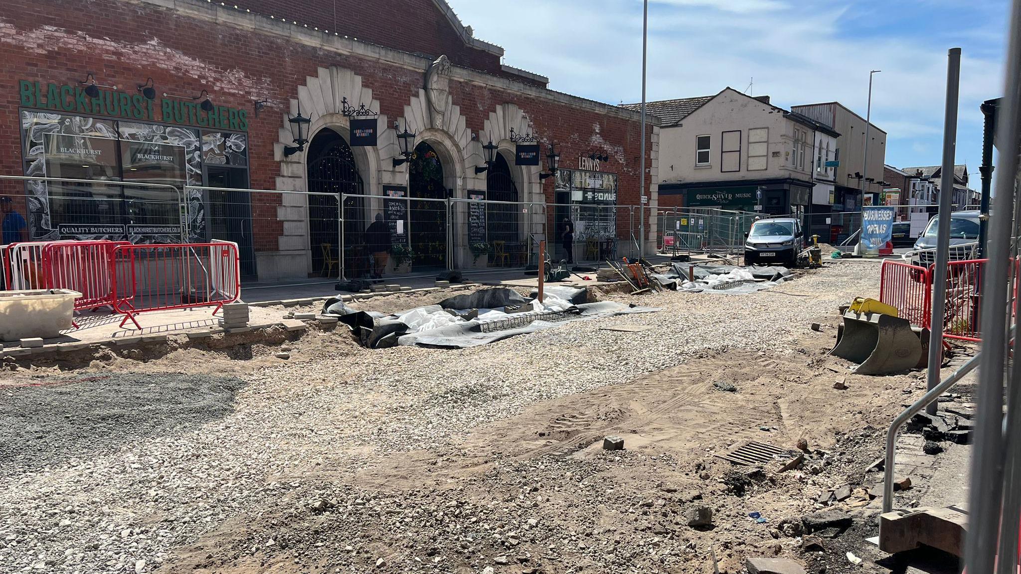 Roadworks on King Street in Southport where the road in completely fenced off and tramac has been removed. Two vans can be seen parked in the distance.