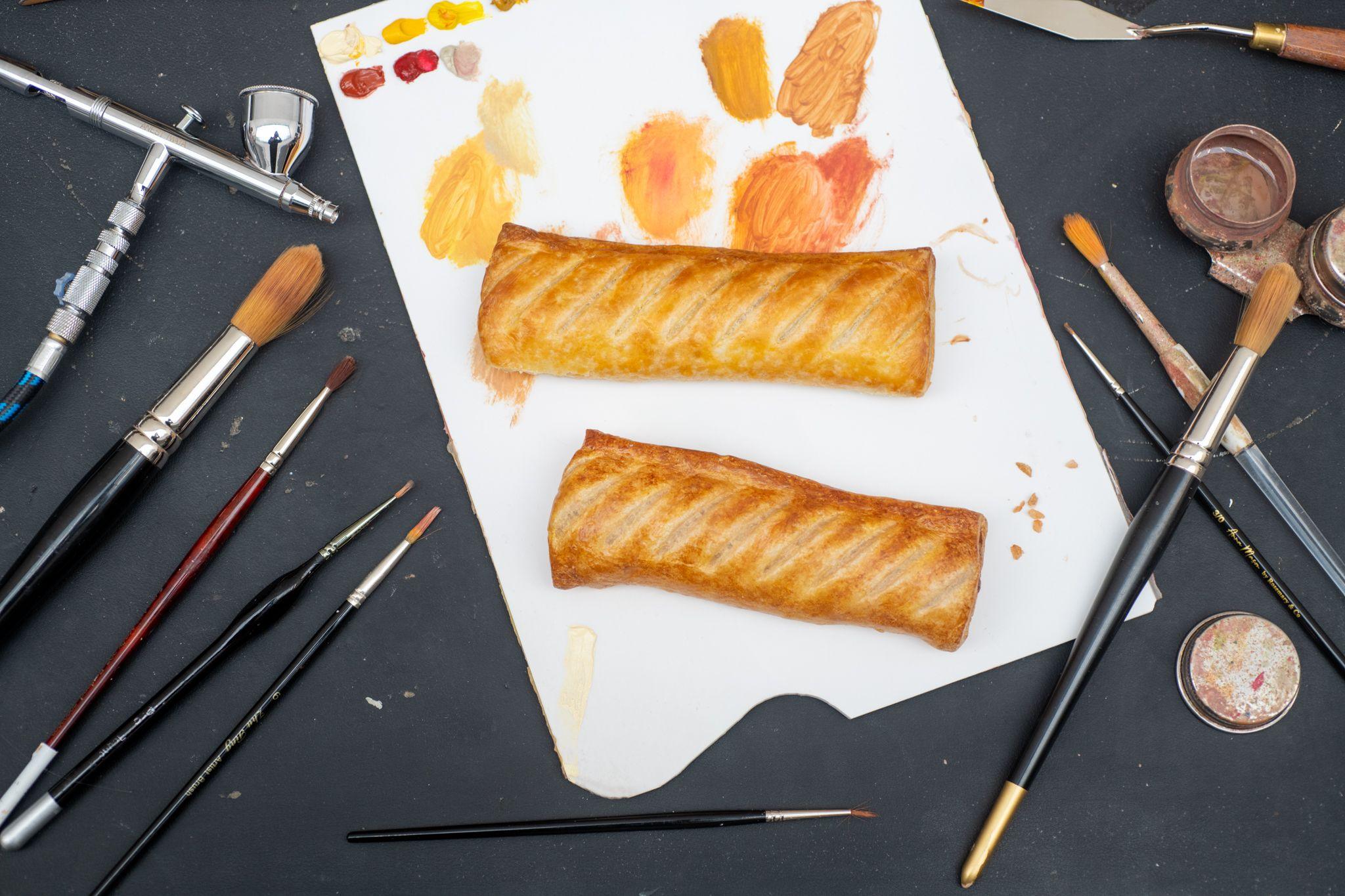 The colours are tested to paint the sausage roll on a white background with paint brushes
