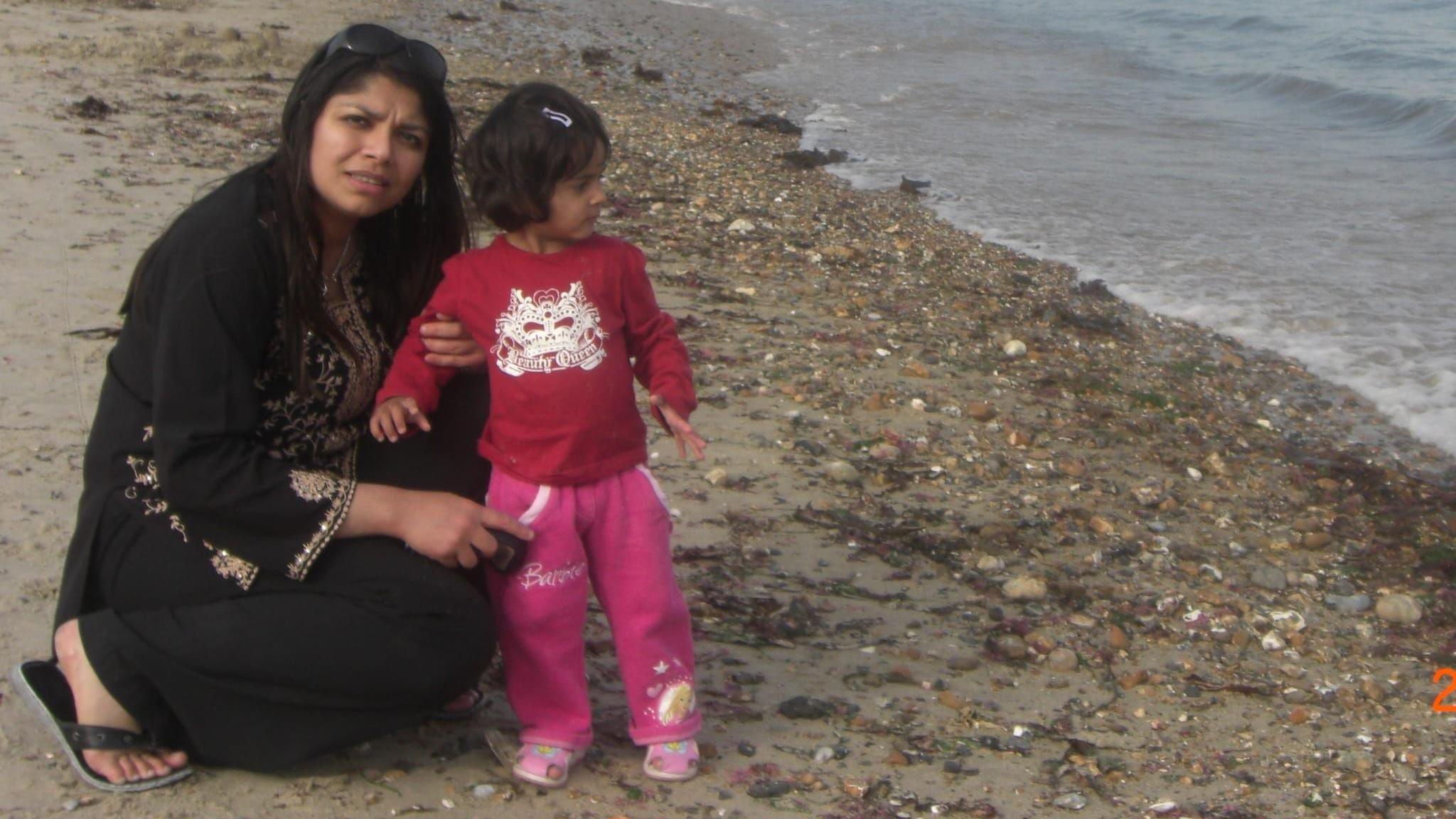 Zobia on the left wearing a black Salwar Kameez which has gold designs with sunglasses on the top of her head and her daughter Mariam who's wearing a red top and barbie pink trousers. 