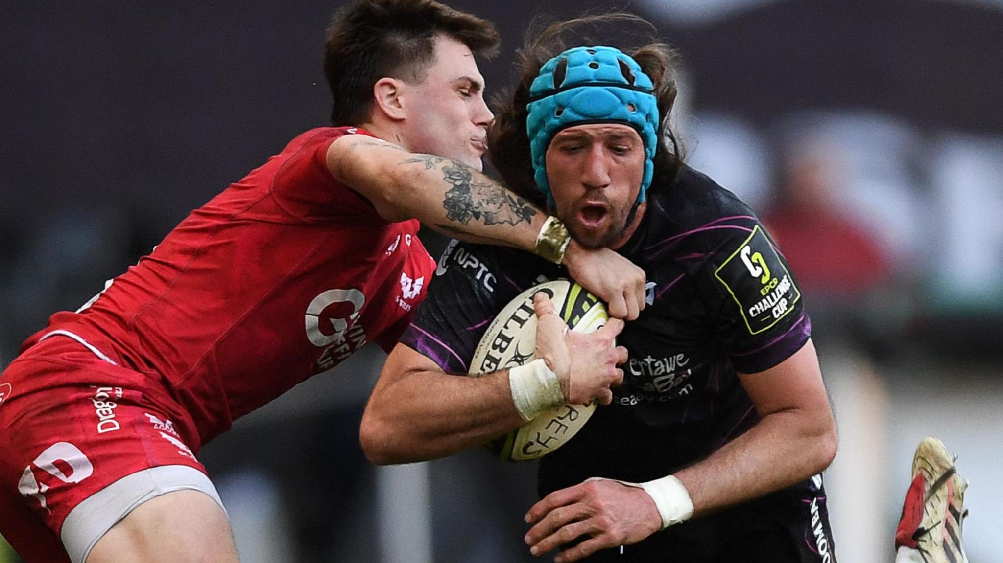Ospreys flanker Justin Tipuric is tackled by Scarlets centre Joe Roberts