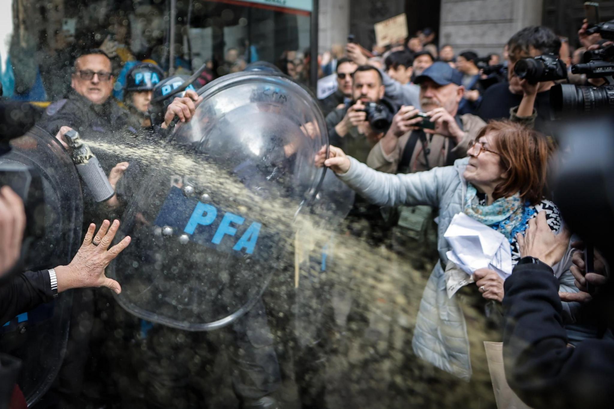 Members of the Argentine Federal Police (PFA) clash with a woman during a protest in Buenos Aires, Argentina