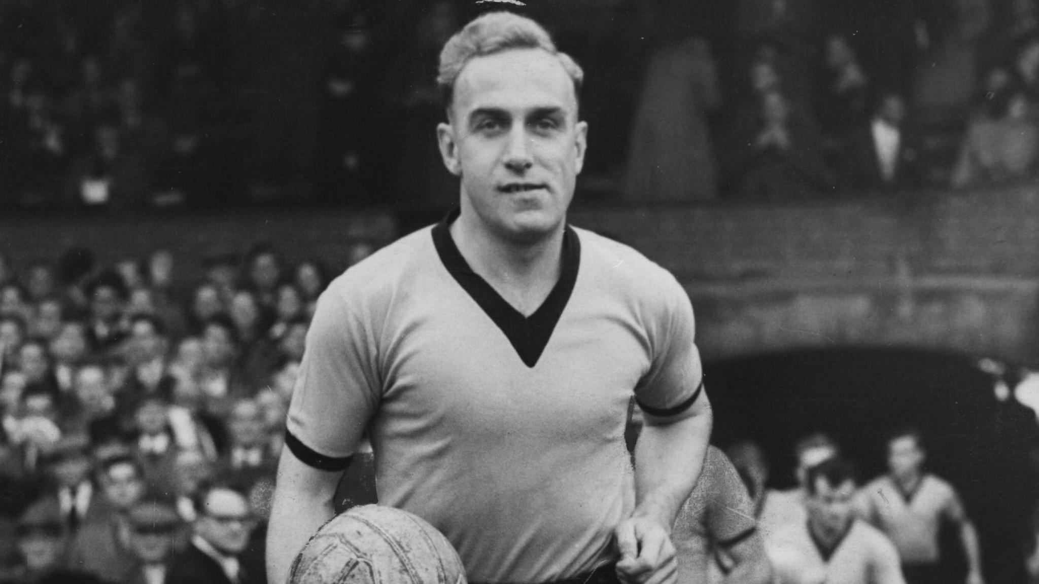 Billy Wright holding a football on a pitch