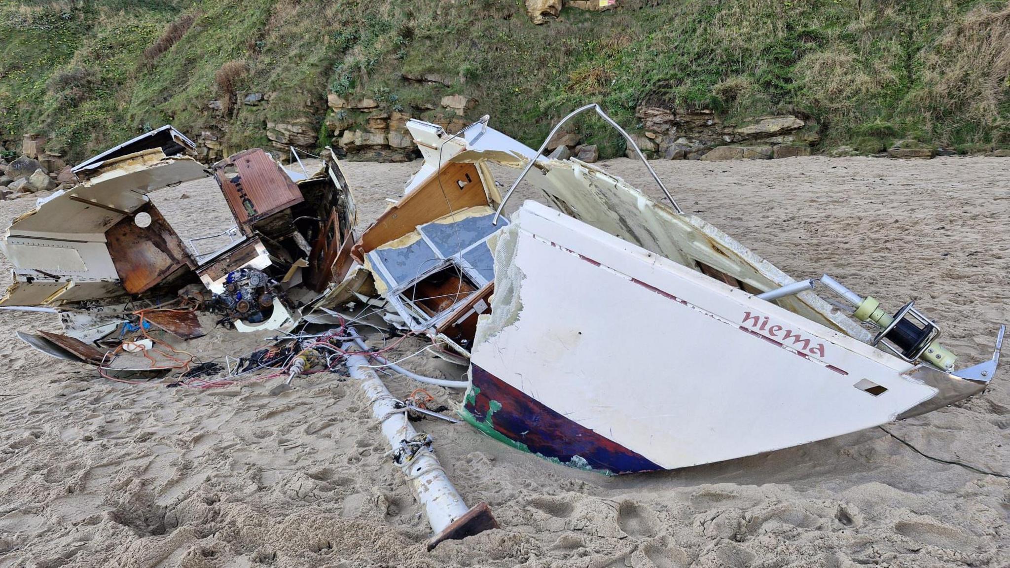 The abandoned yacht, broken in two on sand.