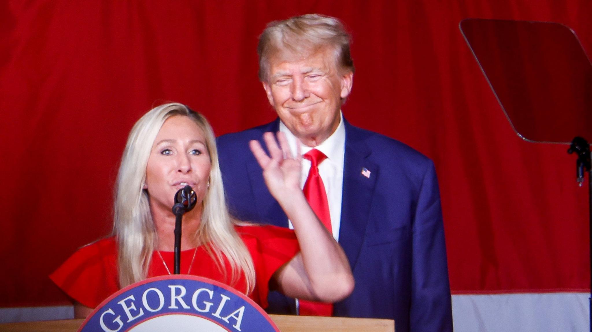  Donald Trump looks on as Rep. Marjorie Taylor Greene speaks during his remarks at the Georgia state GOP convention in 2023