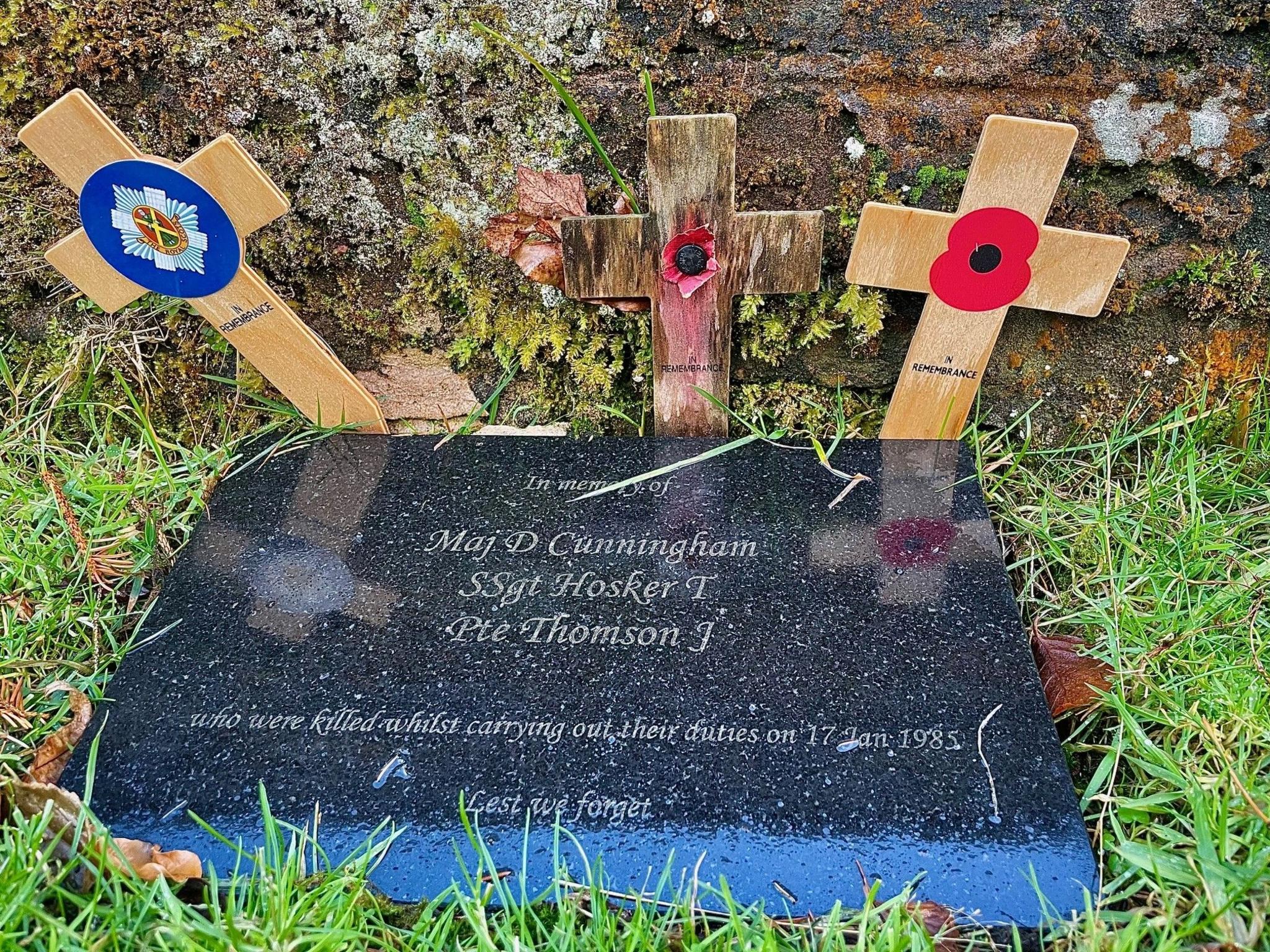 The plaque reads: Maj D Cunningham, S Sgt Hosker T, Pte Thomson J - who were killed whilst carrying out their duties on 17 Jan 1985, Lest we forget.
There are three small wooden crosses behind the plague.