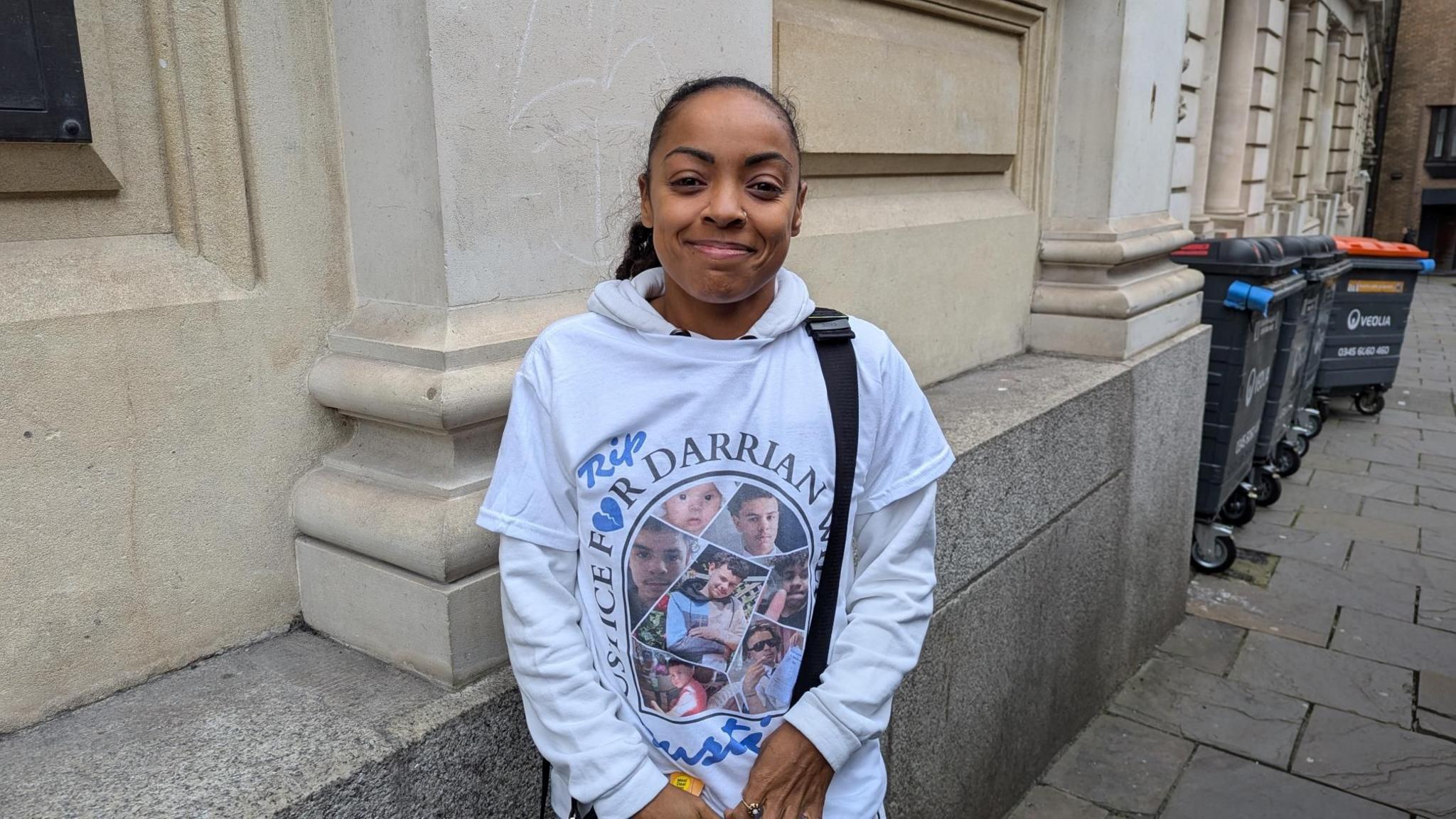 Tiffany Williams standing outside Bristol Crown Court wearing a t-shirt that is a tribute to Darrian Williams.