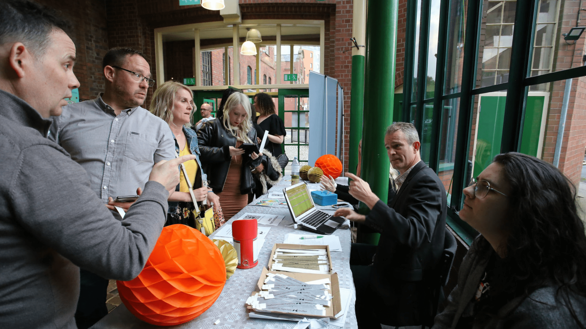 People signing to one another at a stall