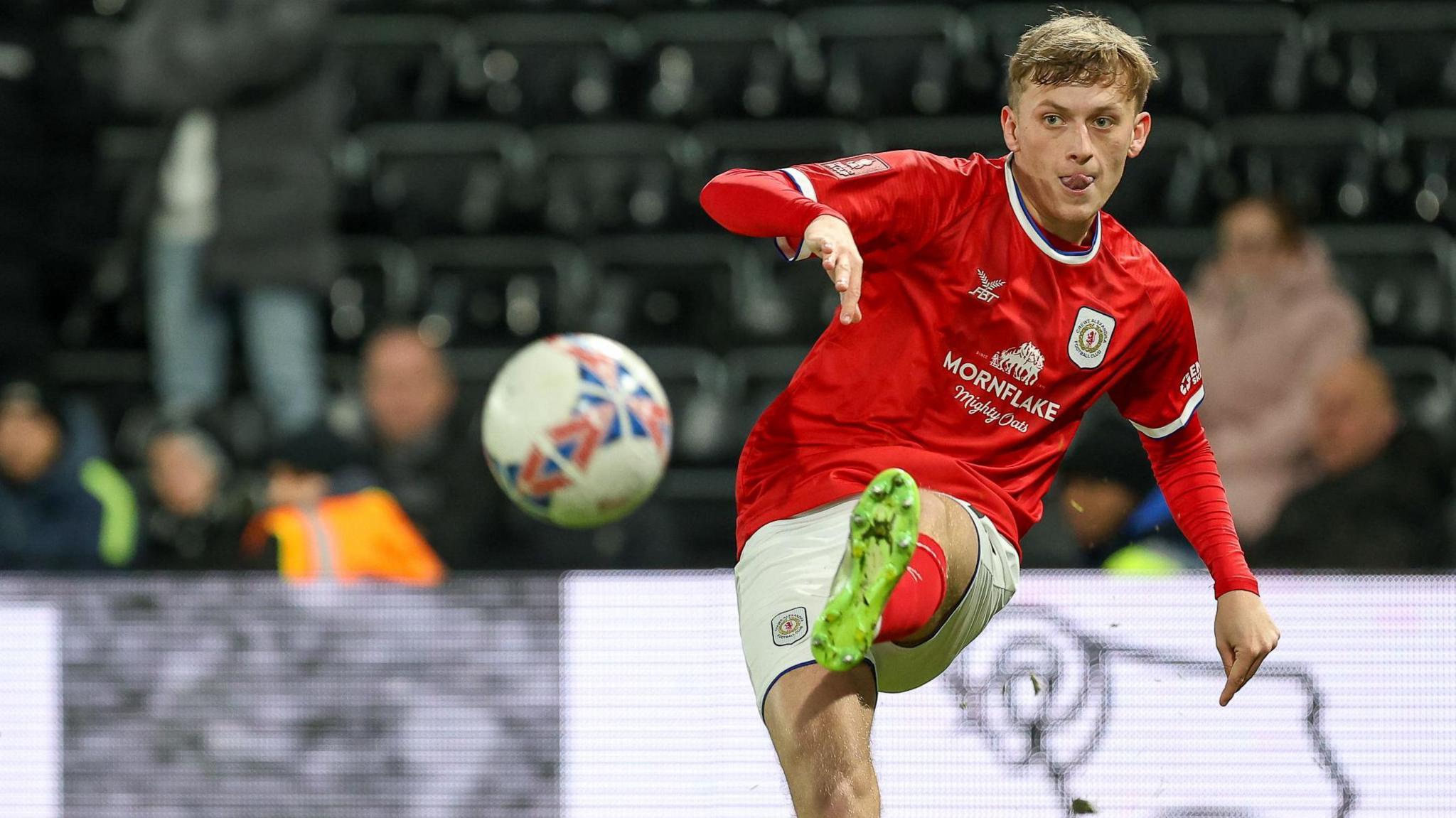 Crewe's Charlie Finney crosses the ball left footed during a game.