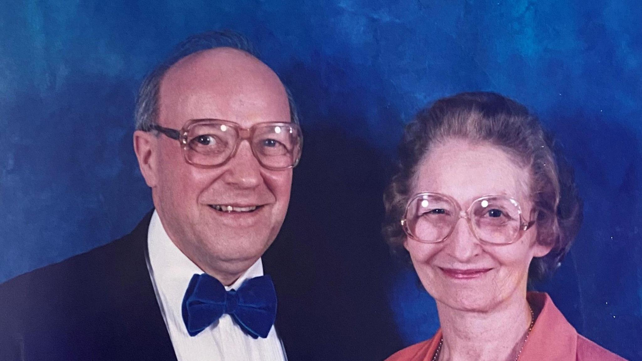 Donald Dixon and his wife Elizabeth. Mr Dixon has salt-and-pepper hair, is wearing glasses and a blue velvet coat and bowtie, with a white shirt. Mrs Dixon has greying permed hair, is wearing glasses and a pink jacket.