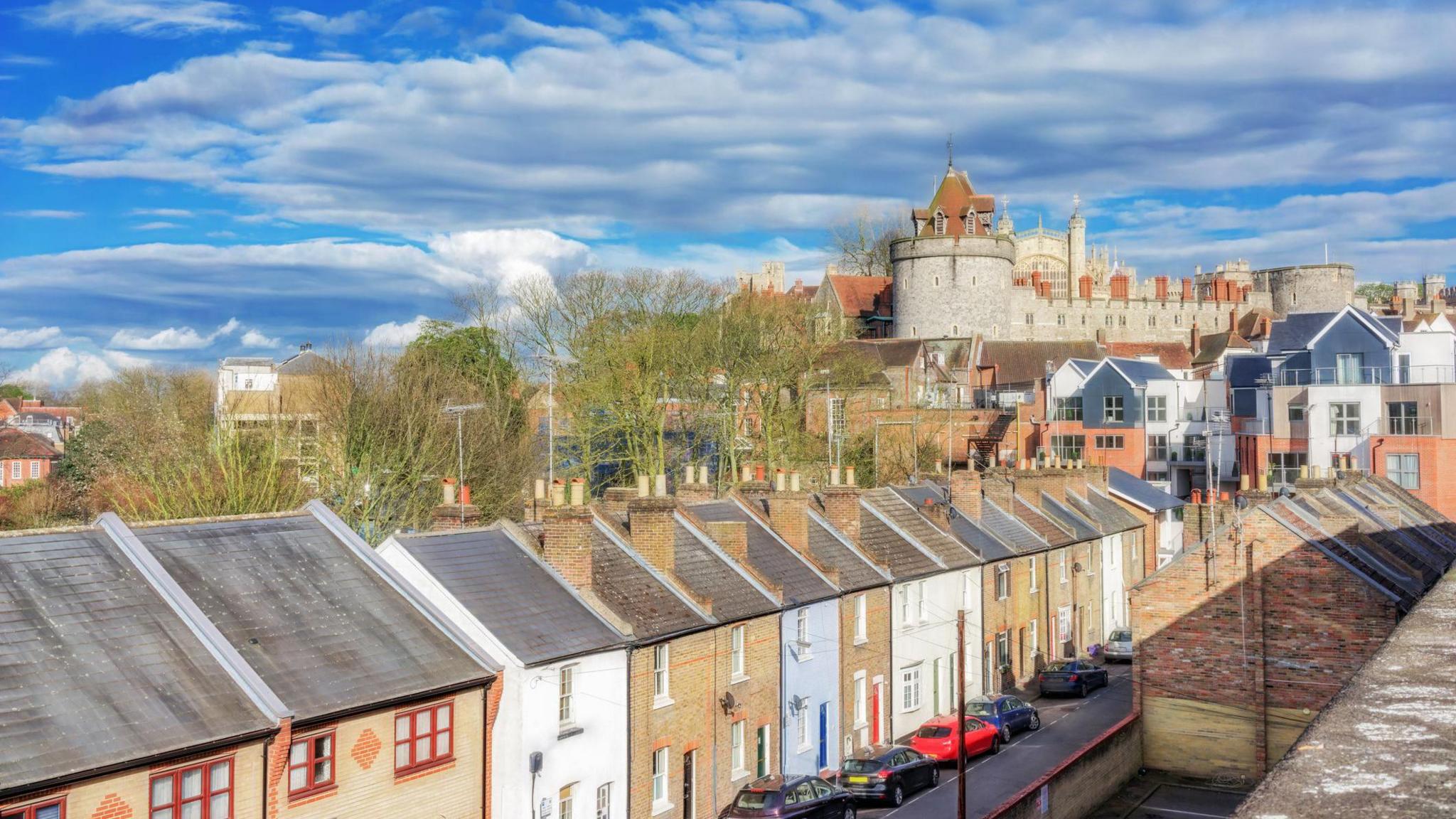 Terraced homes, of different colours and shades, in the shadow of Windsor Castle in Windsor 