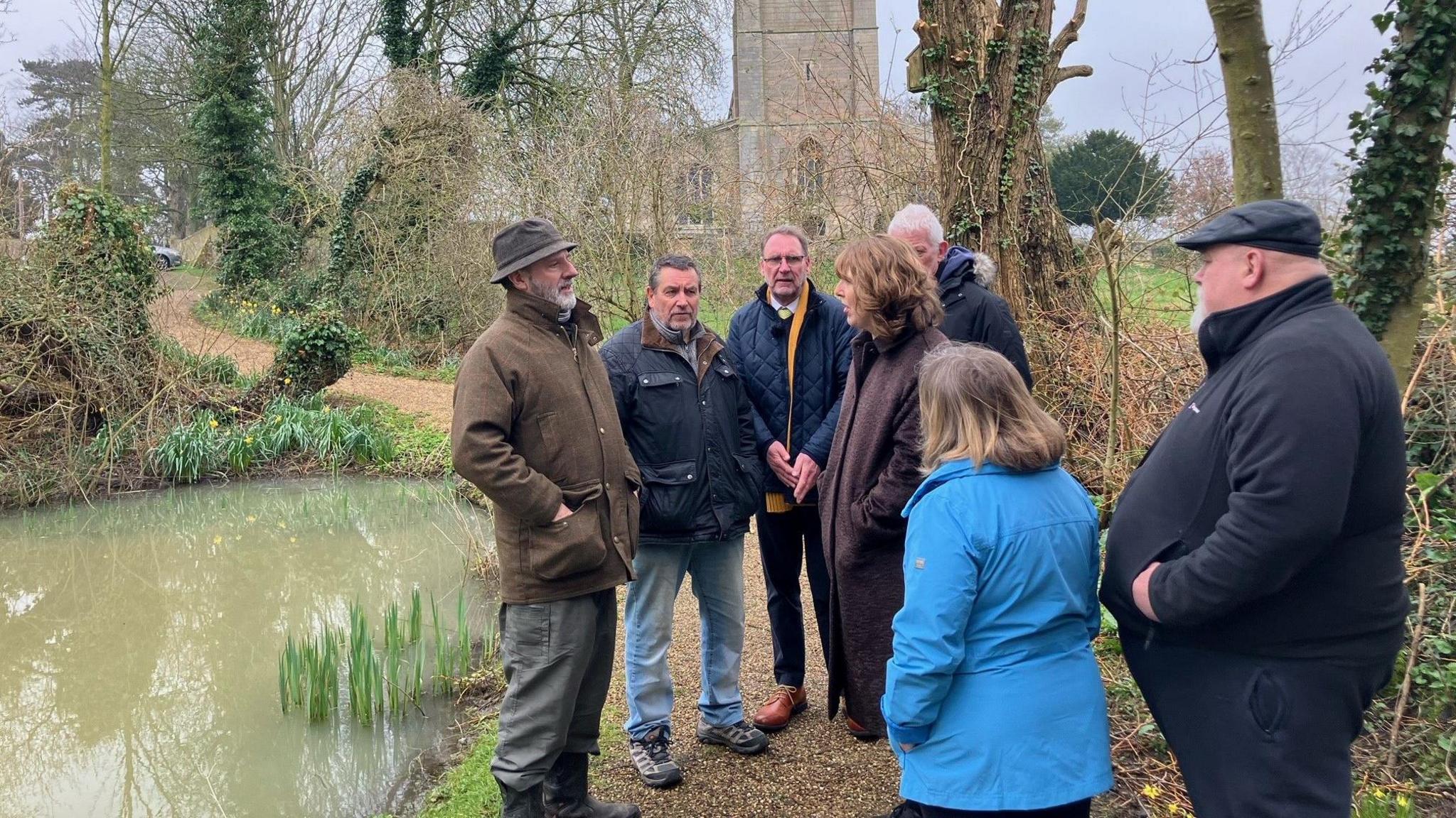 Residents meeting at the flooded pond