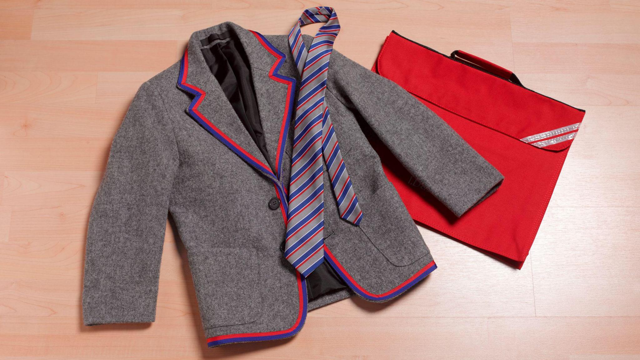 A grey wool blazer with red and navy trim, the grey, red and navy striped tie and a red bag