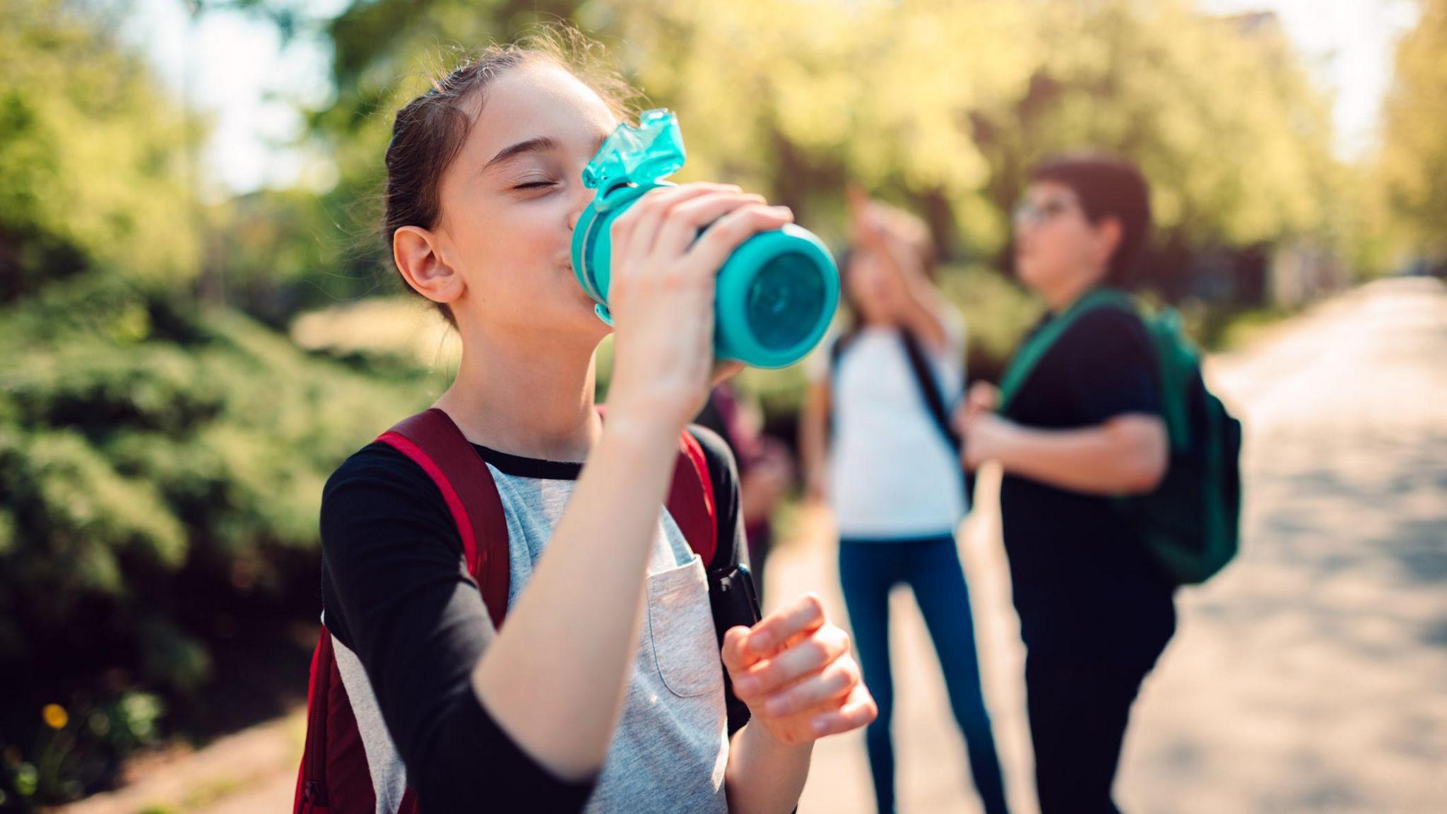 Girl drinking from a water bottle.