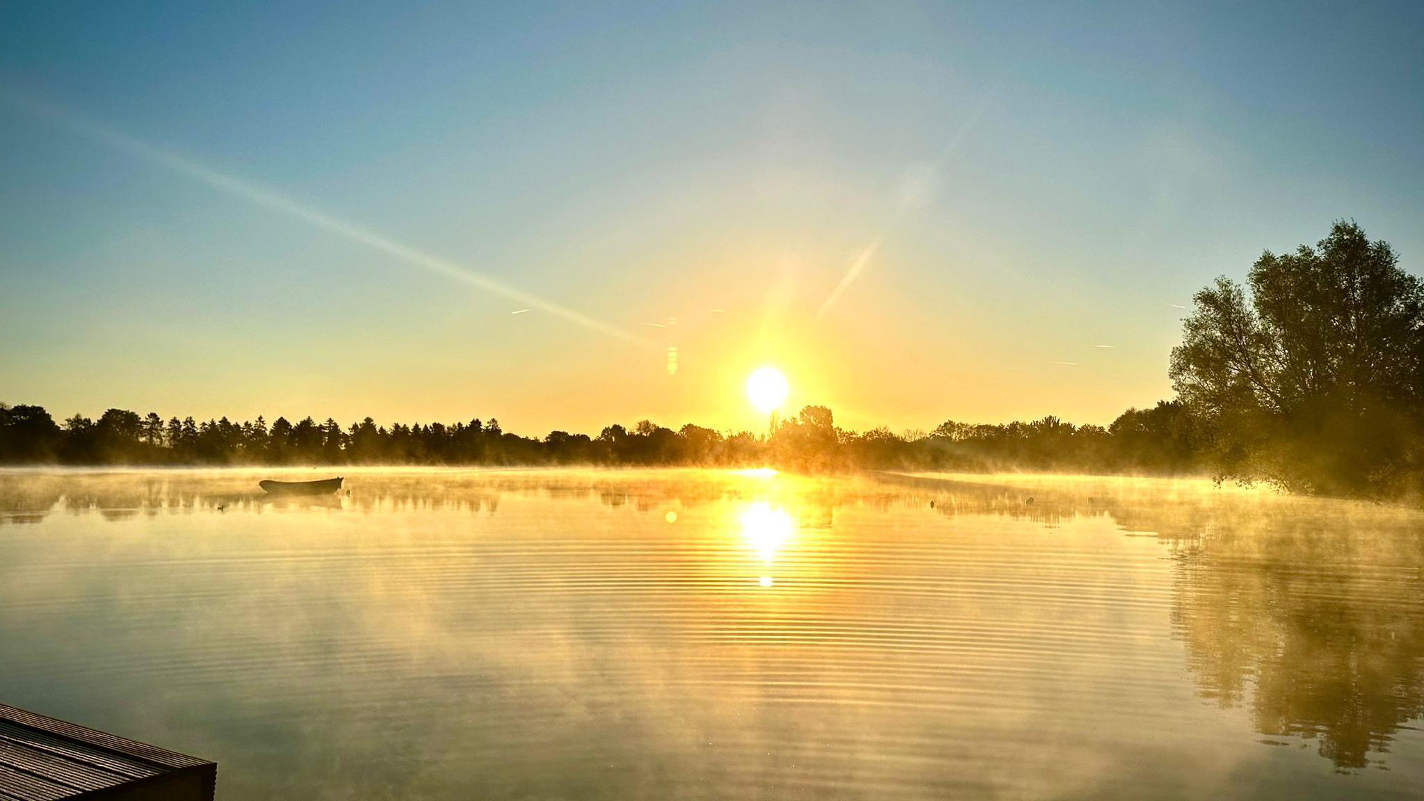 Lake 32 glistening in the early morning sunrise, with the sunrise at the back of the photo 