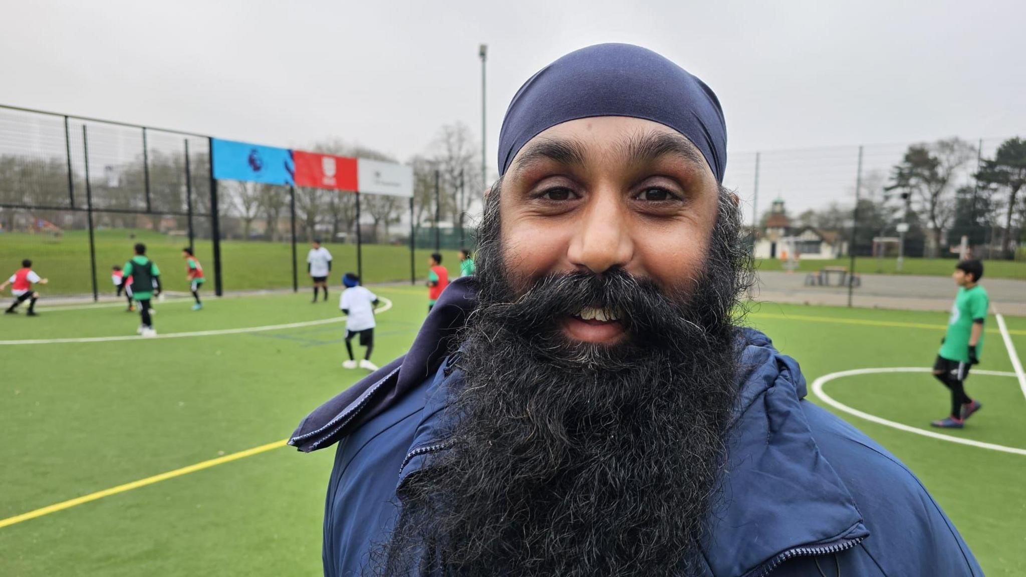 Gurbinder Singh Kooner in front of the new pitch where his pupils are playing