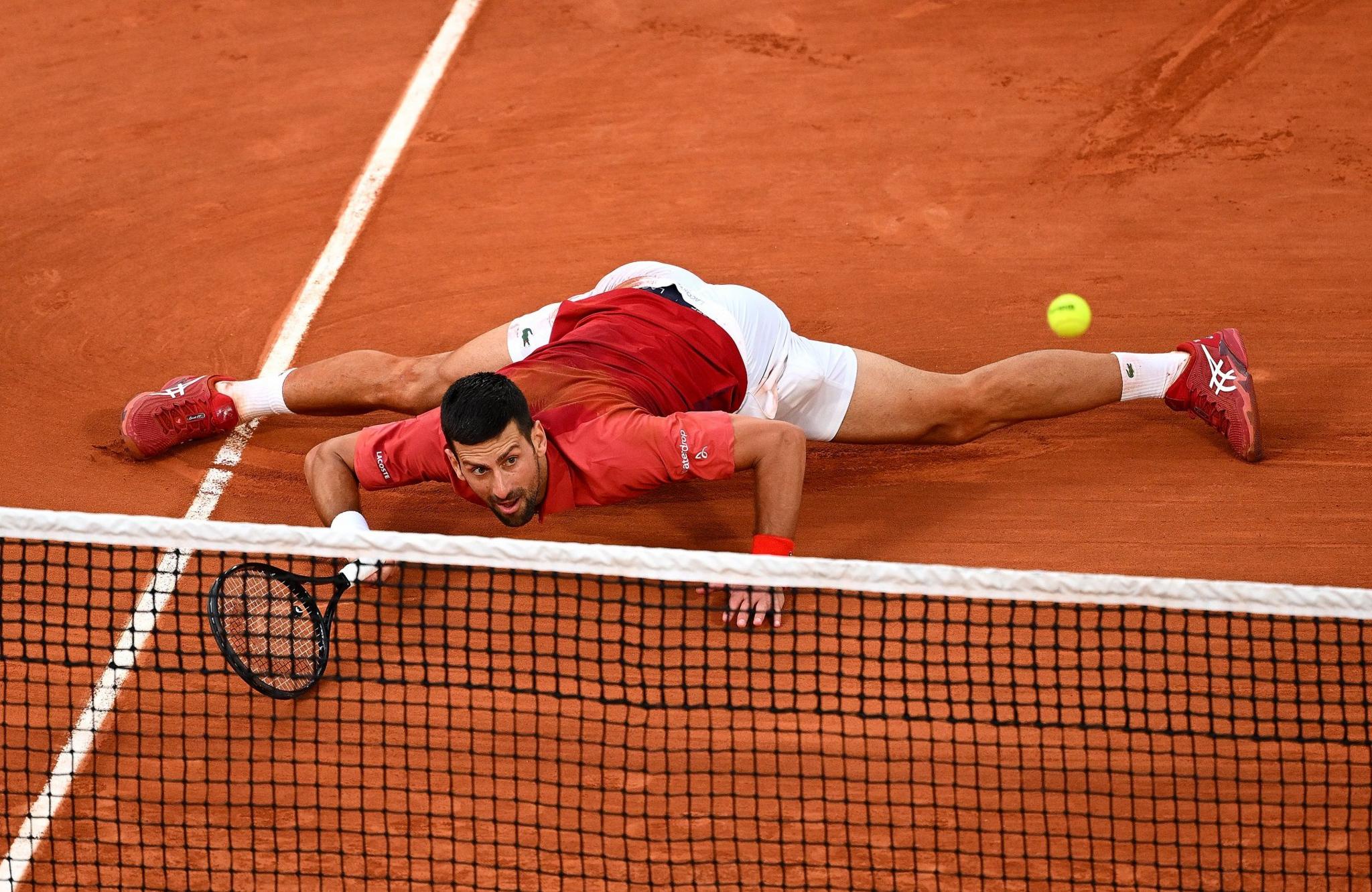 Novak Djokovic slides to play a shot against Francisco Cerundolo of Argentina in the fourth round of the French Open