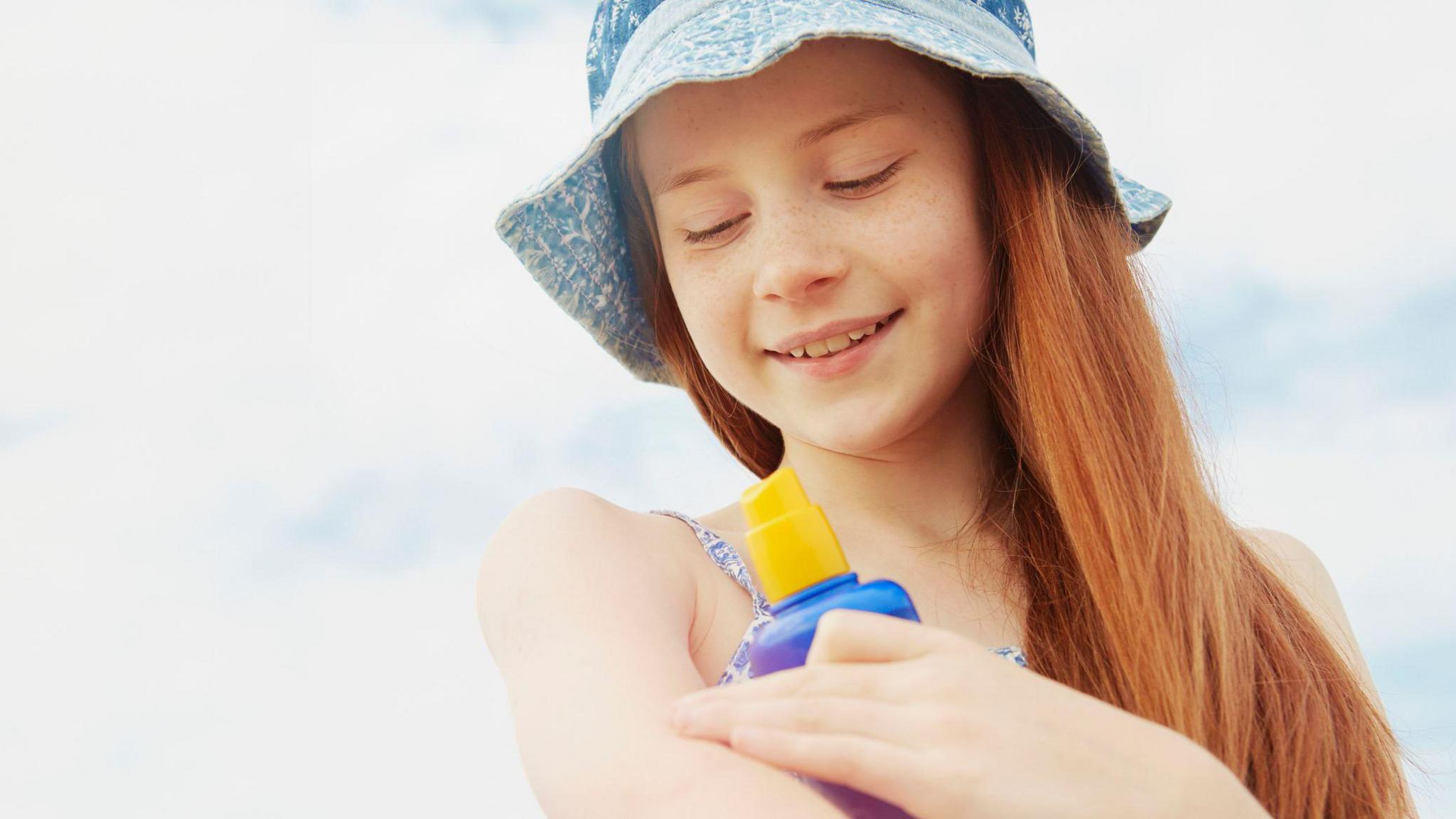 A girl putting on suncream