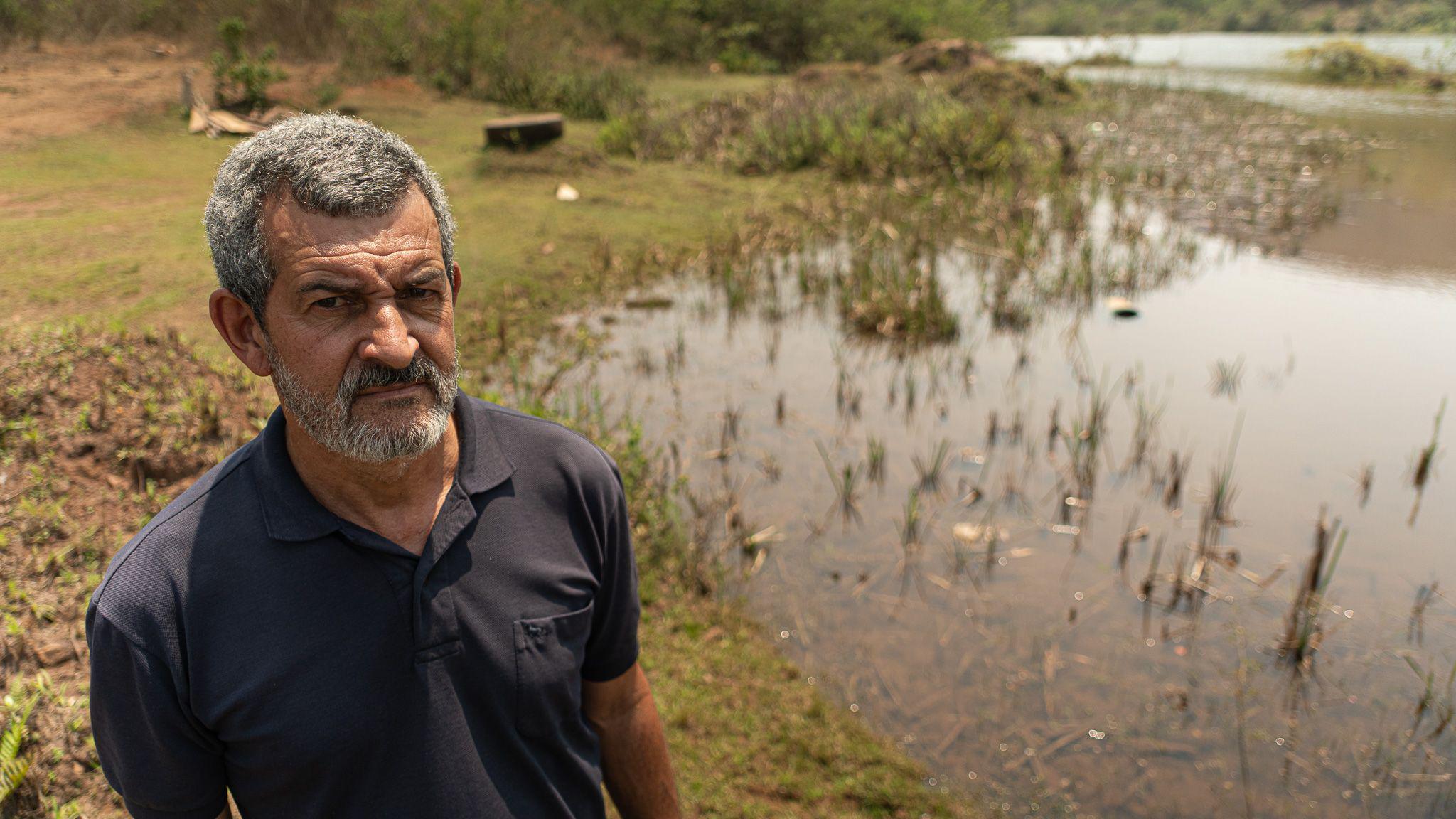 Marquinhos stands by a lake where his house was washed into by the dam collapse