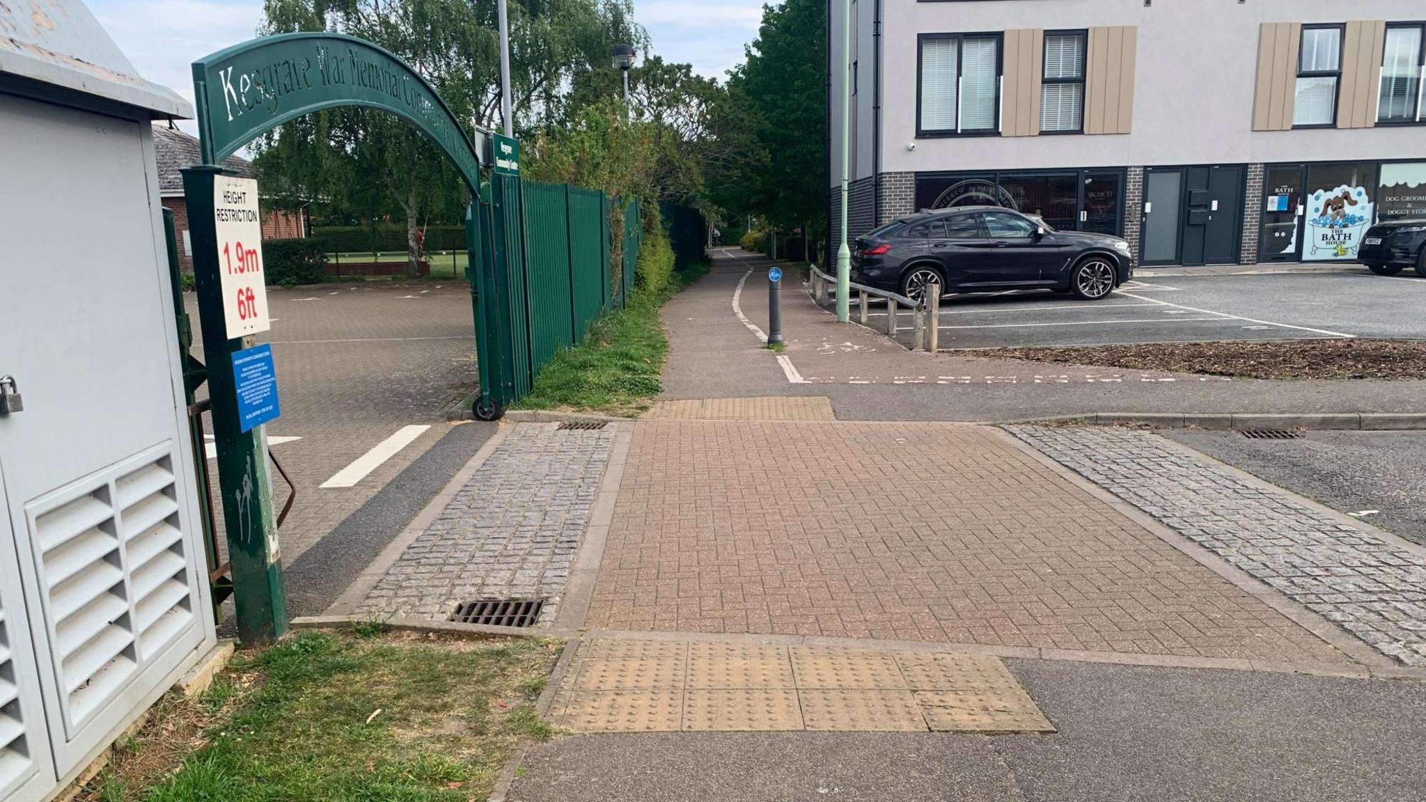 A cycle path in Mead Drive, Kesgrave, where a man was stabbed. The cycle path is in the foreground, with the left turn to Kesgrave Community Centre nearby. A small car park and flats are further along