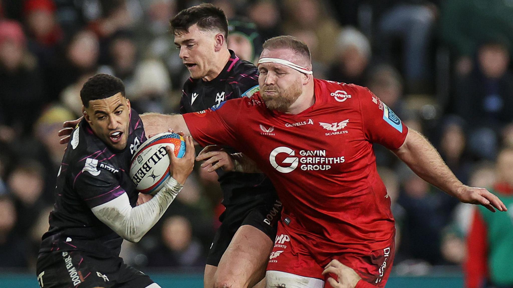 Keelan Giles of Ospreys is challenged by Henry Thomas