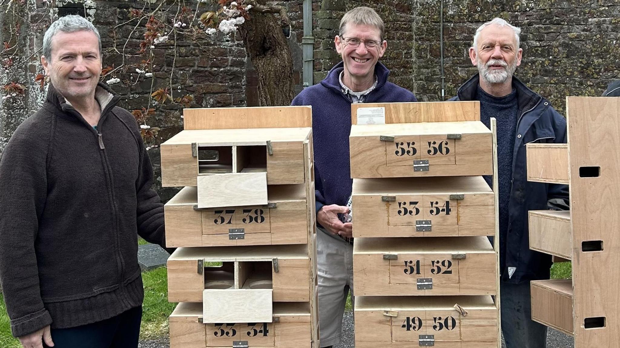 The cabinets of swift boxes with the men who made them.