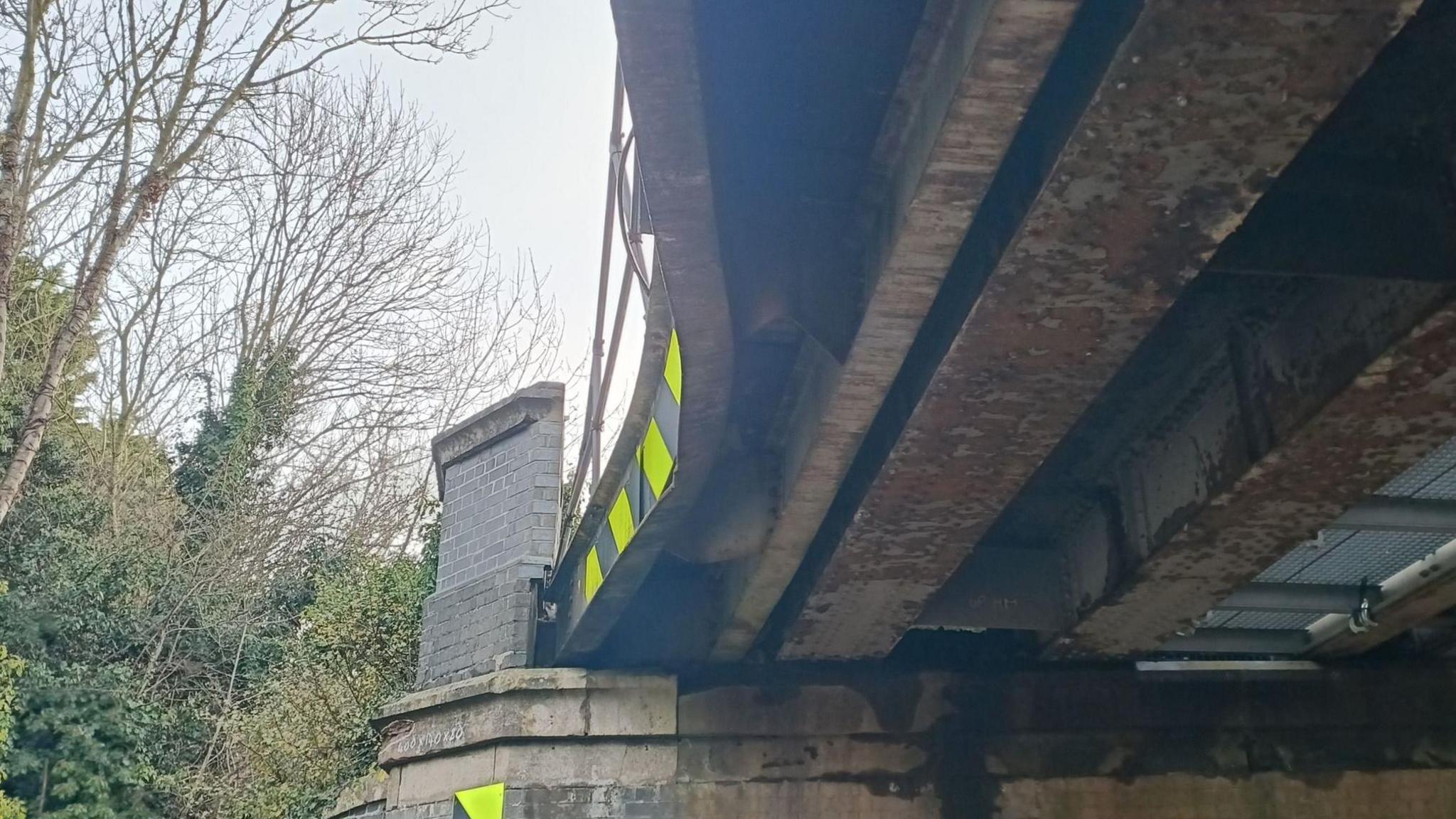 An image of a dent in a railway bridge taken from below the structure. 