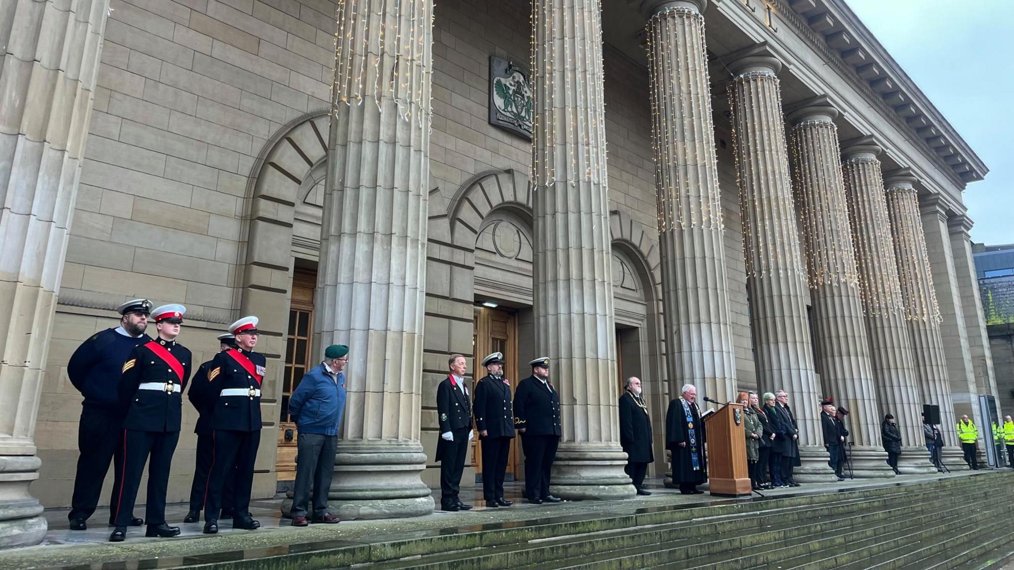 Government officials and military personnel gathered on the steps of the Caird Hall in Dundee's City Square wearing formal attire and paying tribute.