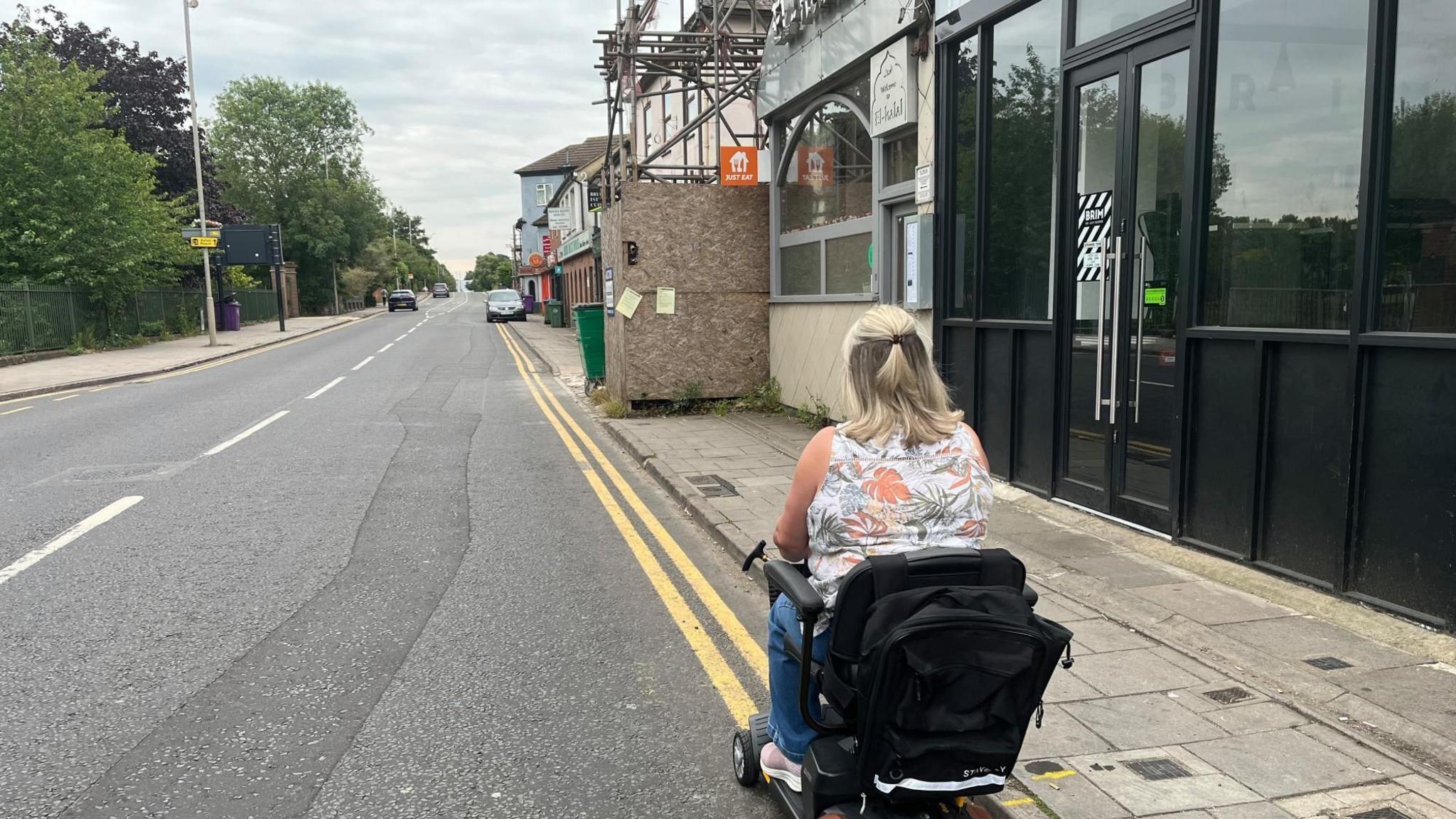Lynda Bell using her scooter on the road